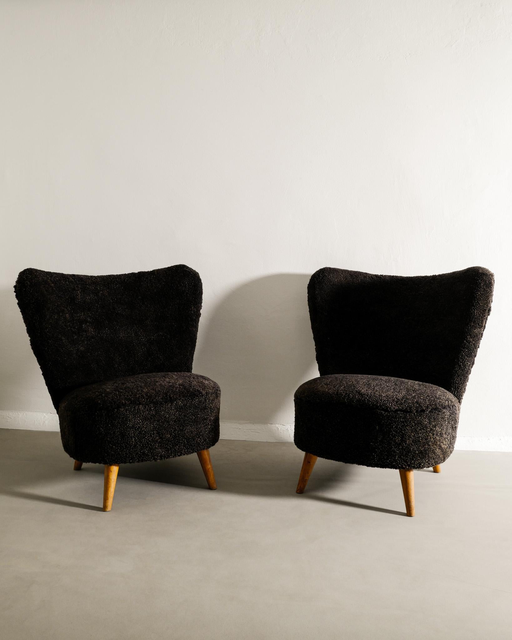 Rare pair of mid century easy chairs produced in Sweden in style of Gösta Jonsson. In great vintage condition. Both chairs have just been professionally restored and upholstered with a dark brown sheepskin. 

Dimensions: H: 78 cm / 30.70
