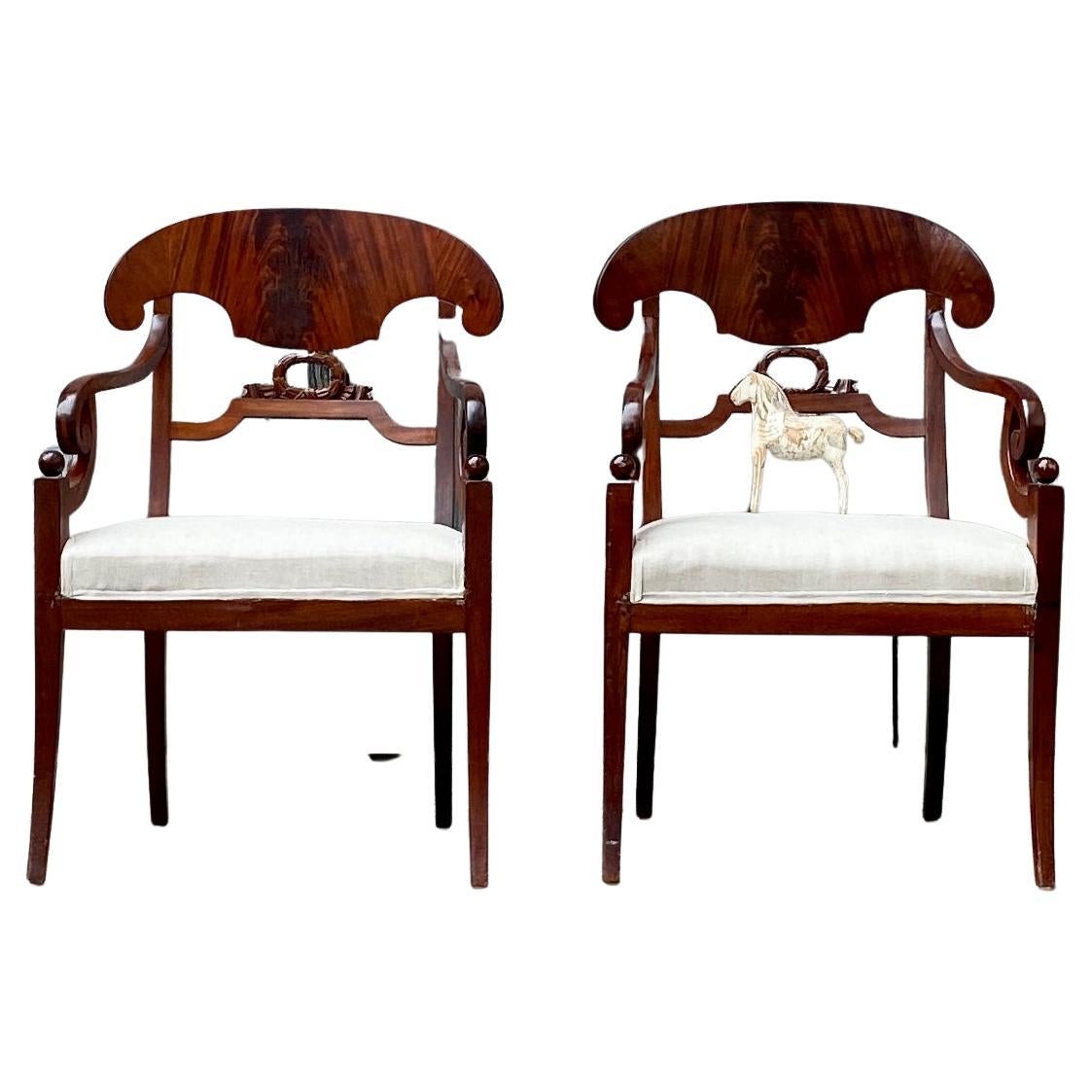 Pair of Stockholm Mahogany Armchairs in the Empire / Karl Johan period, circa 1810-1830 Sweden.
A pair of armchairs are veneered in a beautiful dark brown mahogany and are very classic designed with one carved center decoration. Slight sabre front