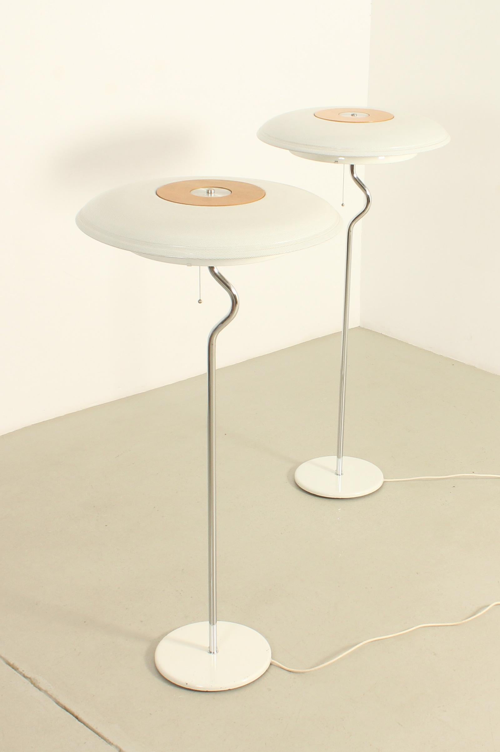 Pair of floor lamps produced in 1980's by Ateljé Lyktan, Sweden. White lacquered metal with chrome plating sterm and a large perforated steel shade with wooden center, round neon light with a diffuser. 