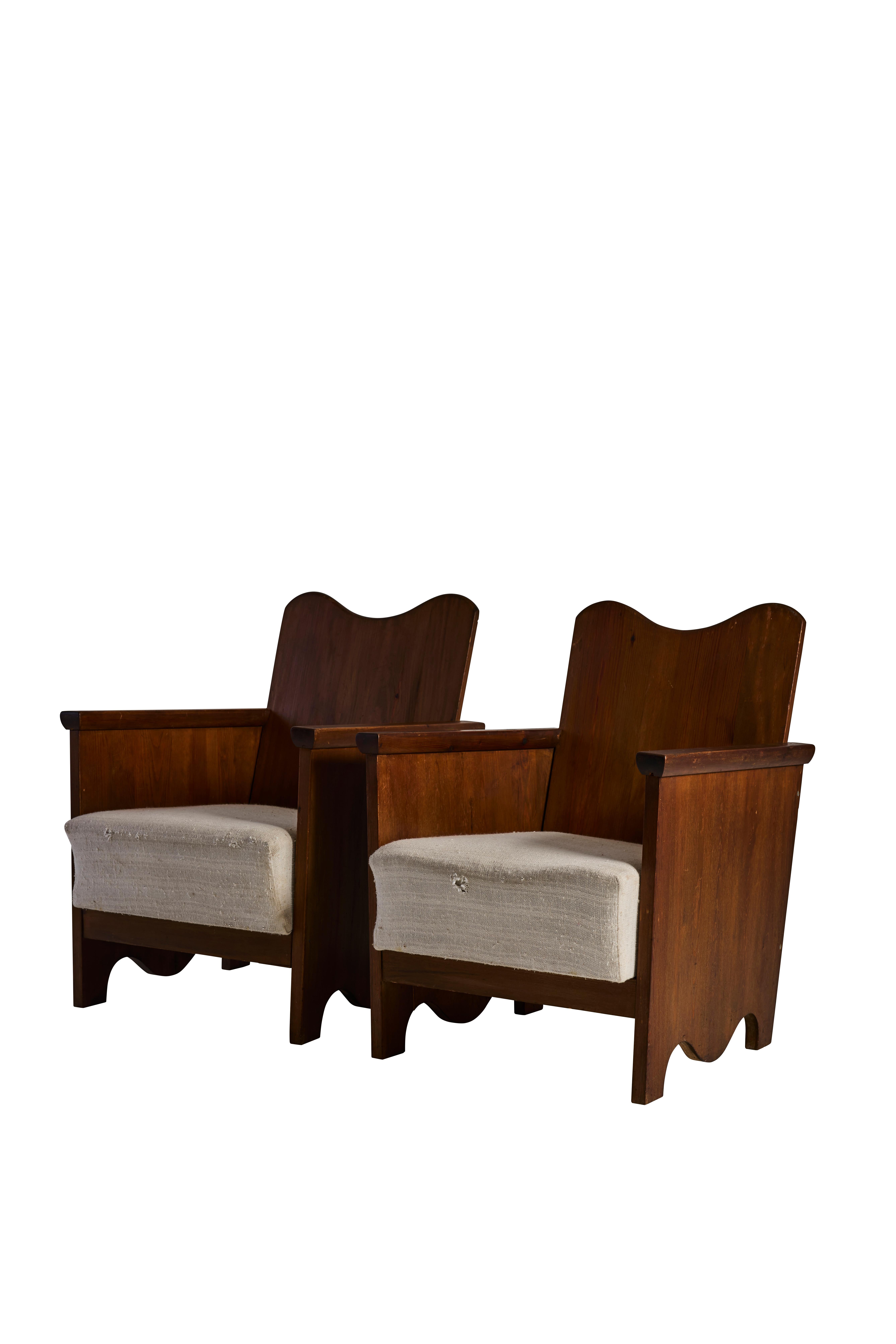 Une paire remarquable de fauteuils en pin fabriqués à la main en Suède, datant des années 1930. Ces chaises sculpturales incarnent l'essence du design folklorique suédois avec leurs silhouettes magnifiquement sculptées, leurs tabliers festonnés et