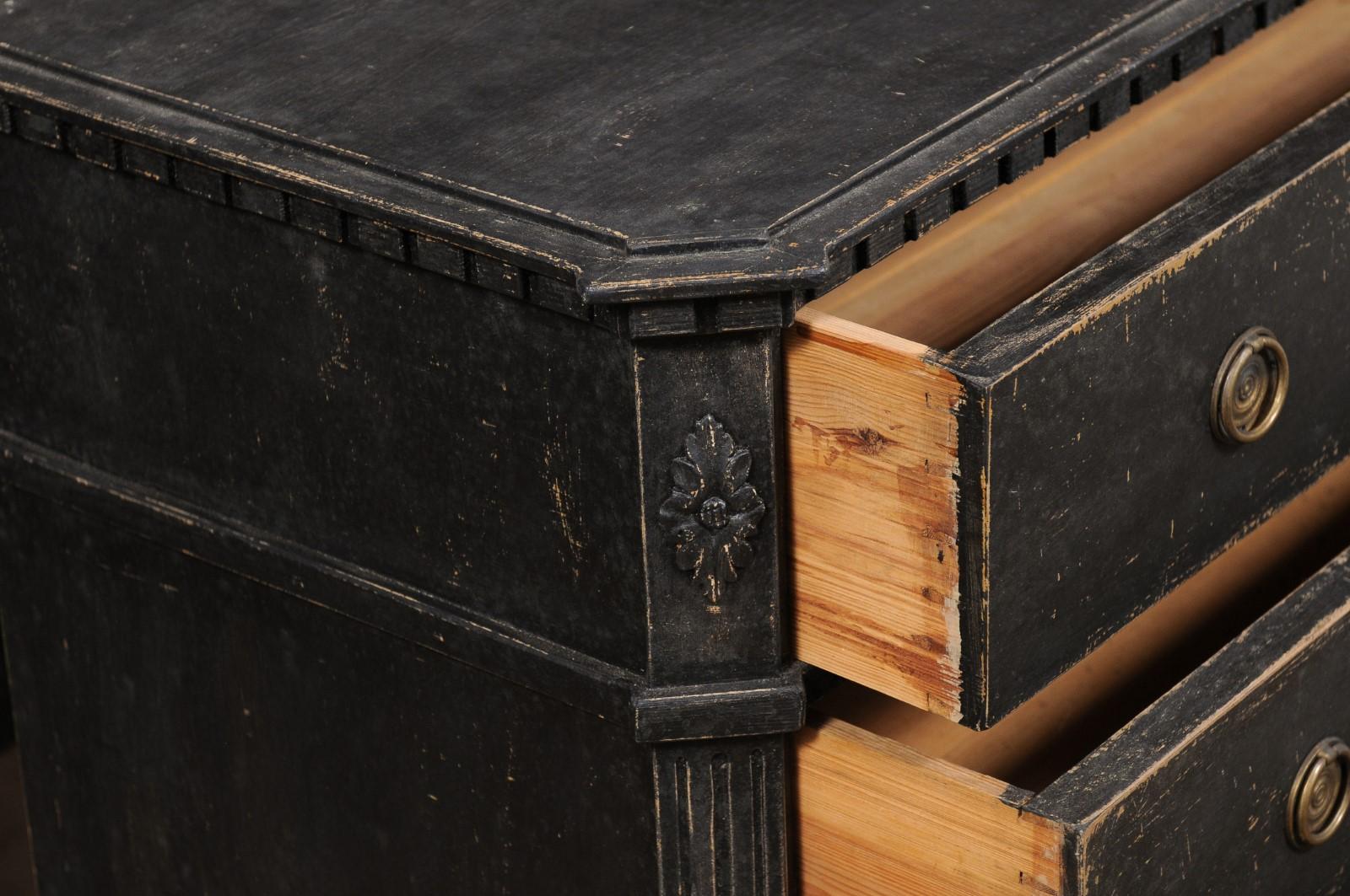 A pair of Swedish Gustavian period black painted chests from the early 19th century, with dentil molding and carved side posts. Created in Sweden during the second quarter of the 19th century, each of this pair of Gustavian chests features a