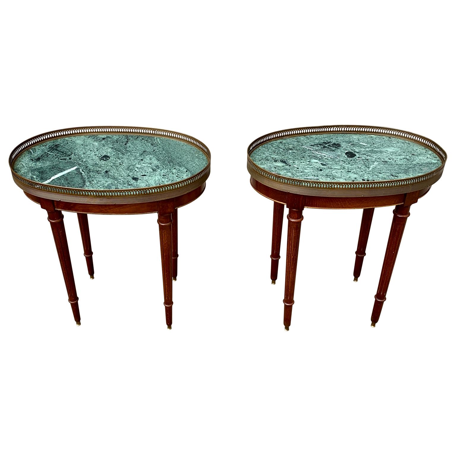 A charming pair of 20th Century Swedish nightstands or night tables in mahogany wood with green serpentine marble tops. These Gustavian brass gallery oval tables with fluted Louis XVI style legs, would be a wonderful addition in a living room