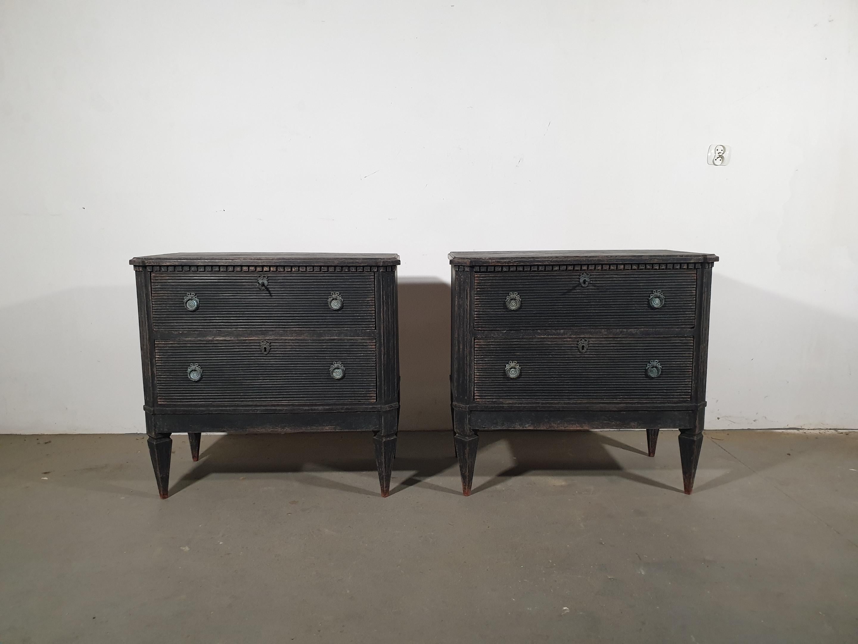 A pair of Swedish Gustavian style painted wood chests from circa 1870 with two fluted drawers, fluted side posts, tapered legs and classical hardware. This exquisite pair of Swedish Gustavian style chests, dating back to circa 1870, exude a timeless