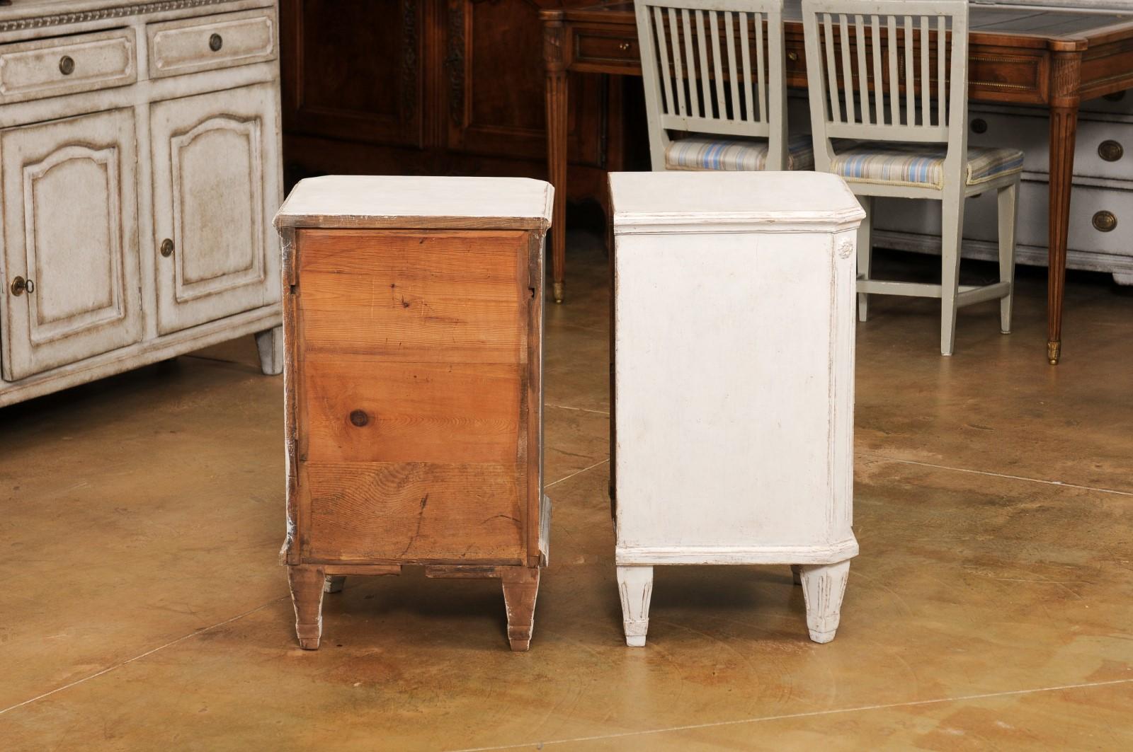 A pair of Swedish Gustavian style painted wood nightstands from the late 19th century, with single drawer over door. Created in Sweden during the last quarter of the 19th century, each of this pair of Gustavian style bedside tables features a