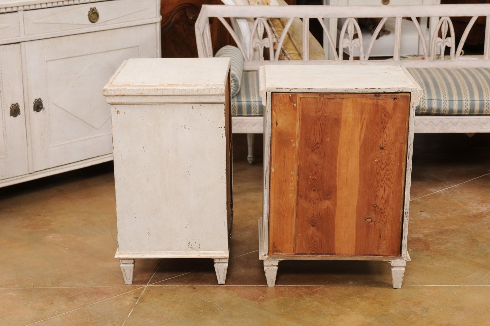 A pair of Swedish Gustavian style painted wood nightstand tables from the early 20th century, with carved diamond motifs, dentil molding and four drawers. Created in Sweden during the Turn of the Century which saw the transition between the 19th to