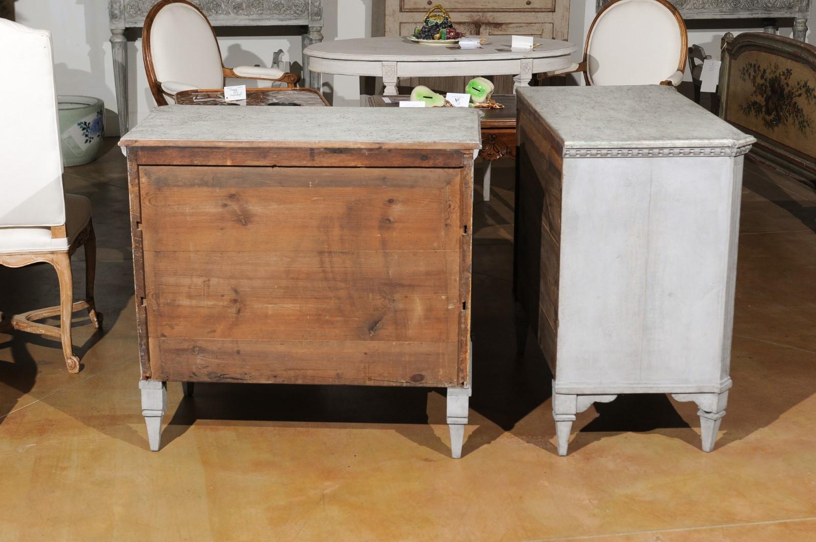 A pair of Swedish Gustavian style painted wood three-drawer chests from the 19th century, with elongated diamond motifs, dentil molding and fluted accents. Born in Sweden during the 19th century, each of this pair of chests features a rectangular