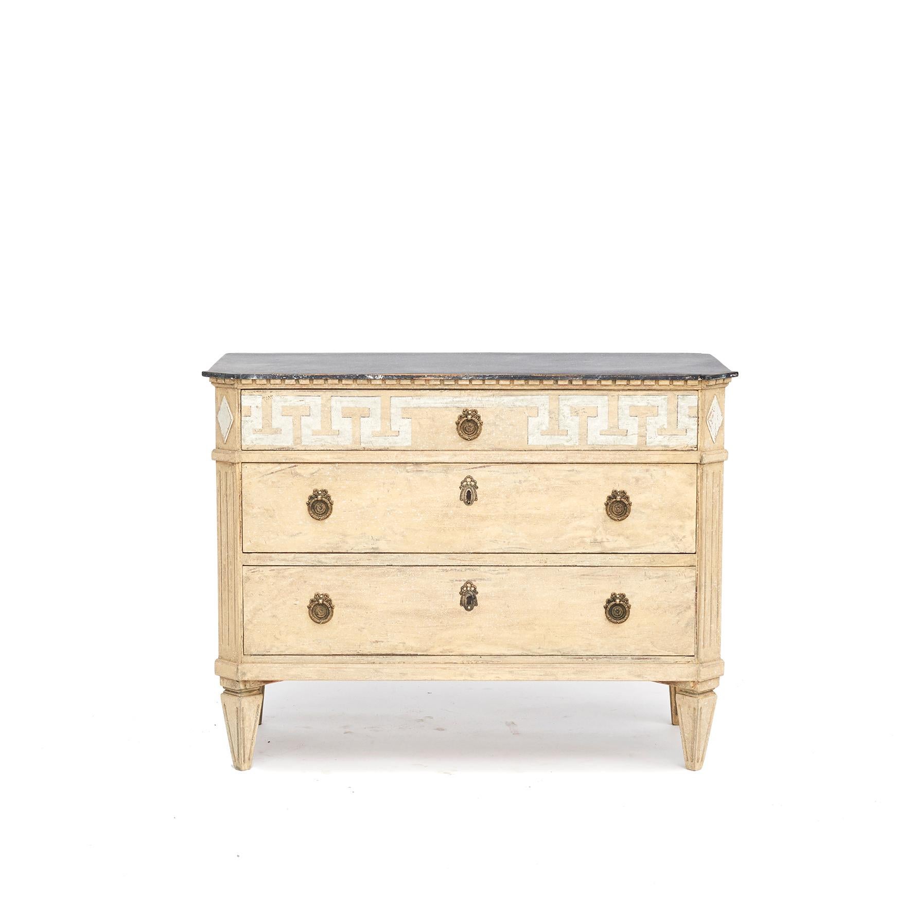 Decorative Swedish Gustavian Style chest of drawers painted in dusty antique yellow, typical of the Scandinavian taste for light palettes.
Wooden blue-gray faux marbled tabletop and dentil mouldings.
Three drawer, upper drawer decorated with white
