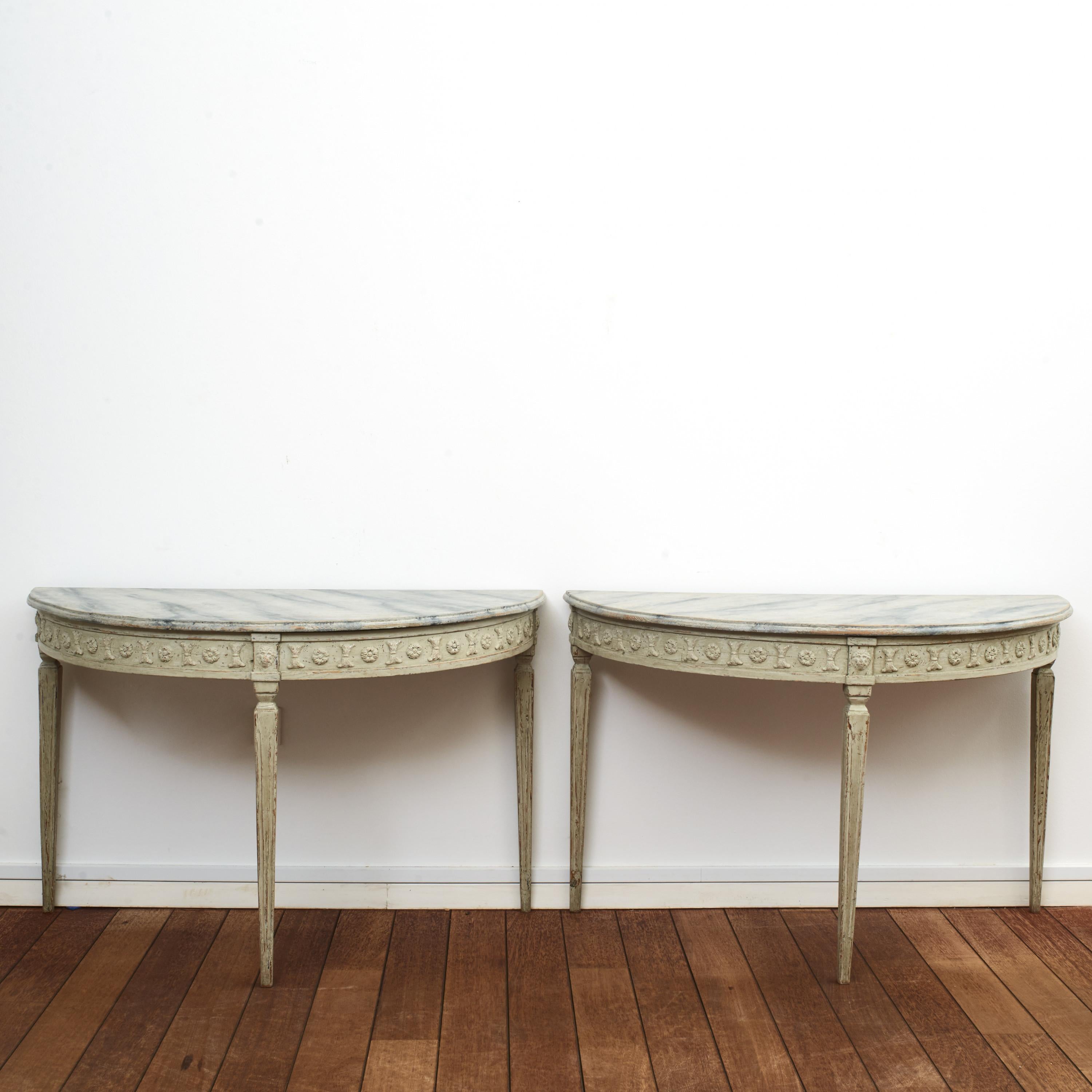 Pair of Swedish demilune Gustavian style console tables on tapered fluted legs.
Later professionally painted and decorated in light grey and blue shades.
Tabletop blue-gray marbled.
Sweden, circa 1840.