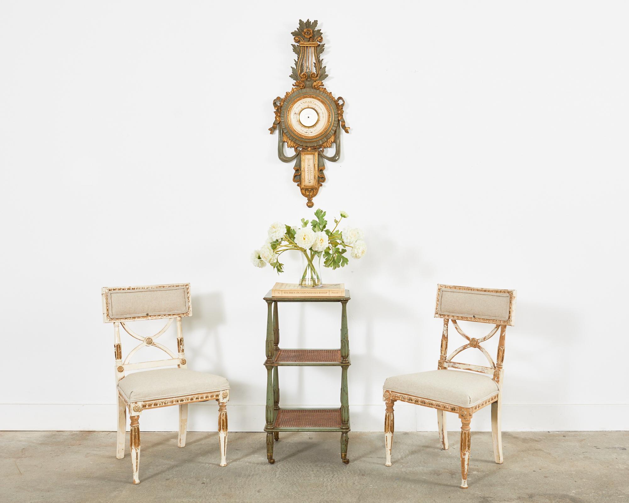 Gorgeous pair of 19th-century Swedish drink tables made in the neoclassical gustavian taste. The lacquered three-tier tables feature a marble tile stone inset top and two hand-caned shelves. The shelves are supported by tulip bud vase shaped legs