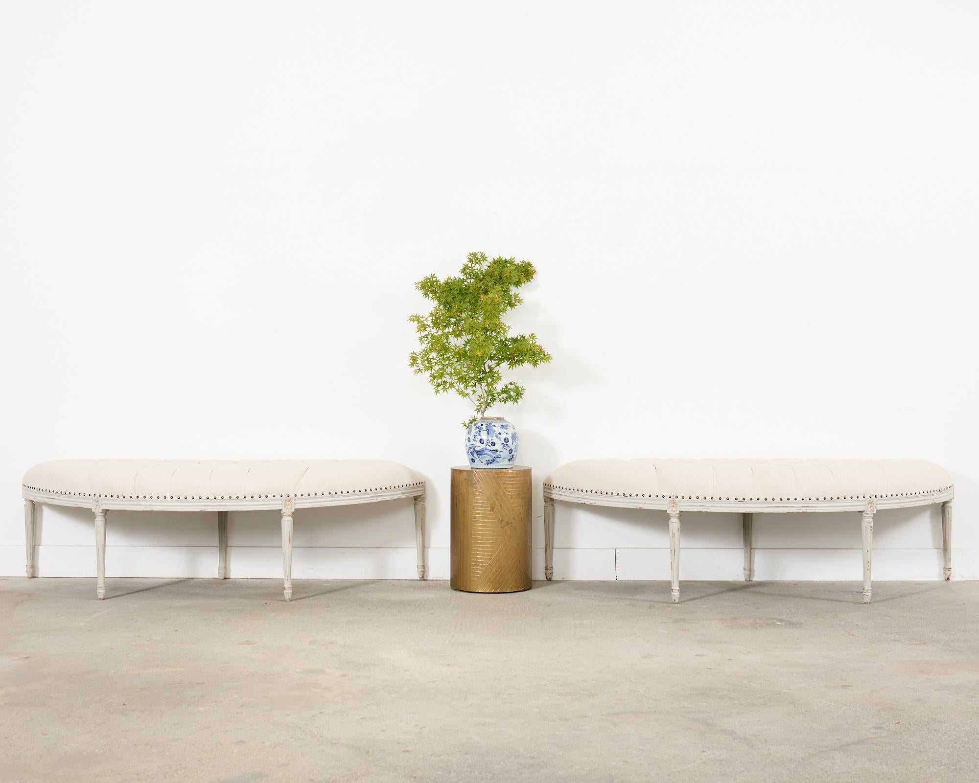 Grande paire de bancs assortis en forme de demi-lune peints dans le goût gustavien suédois de Louis XVI. Les bancs présentent une structure peinte avec une patine volontairement vieillie et en détresse sur la finition. Les cadres ont un tablier