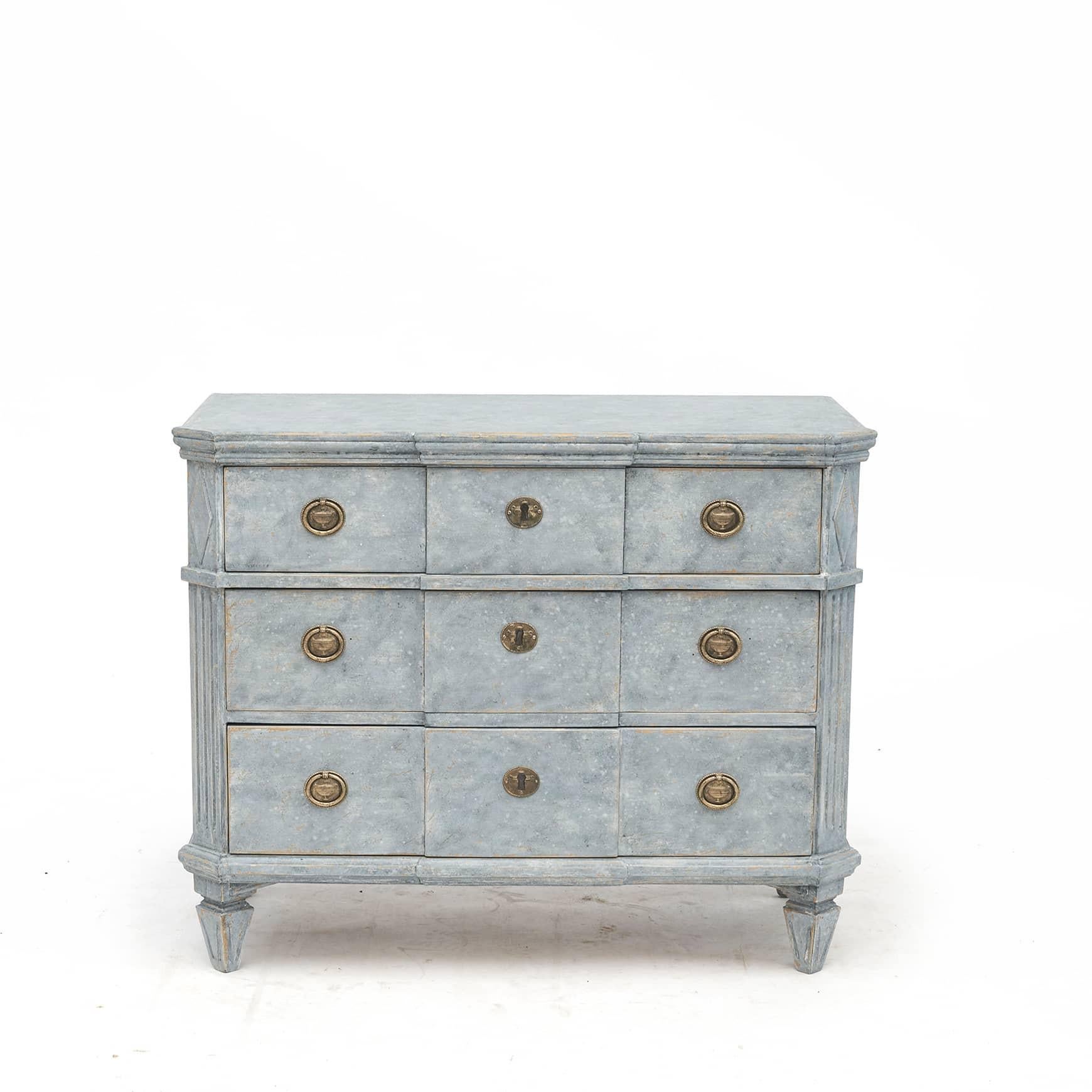 A pair of Swedish Gustavian style painted pine wood chest of drawers from the 19th century.
Each of this pair of blue painted chests features 3 breakfront drawers flanked by canted sides with traditional flutings and diamond motif at the top.
