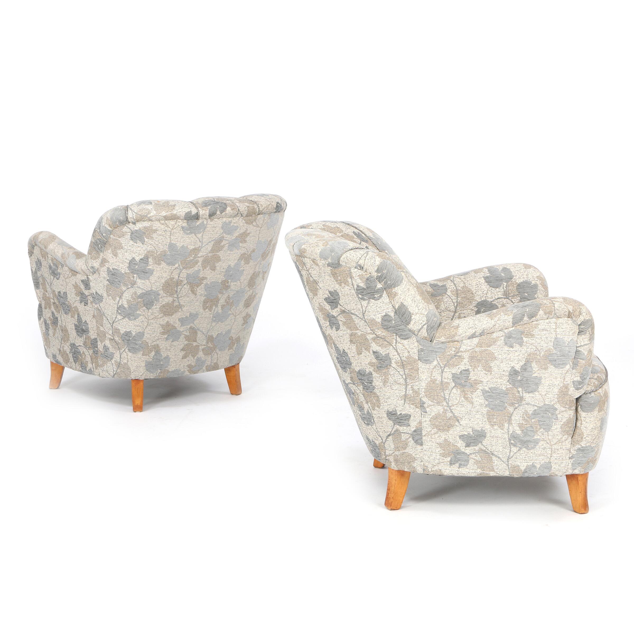 Swedish furniture design: A pair of comfortable easy chairs with channelled backs, legs of birch. Seat, sides and back upholstered with flowered grey wool. Manufactured by 1940s-1950s. There is a matching sofa.