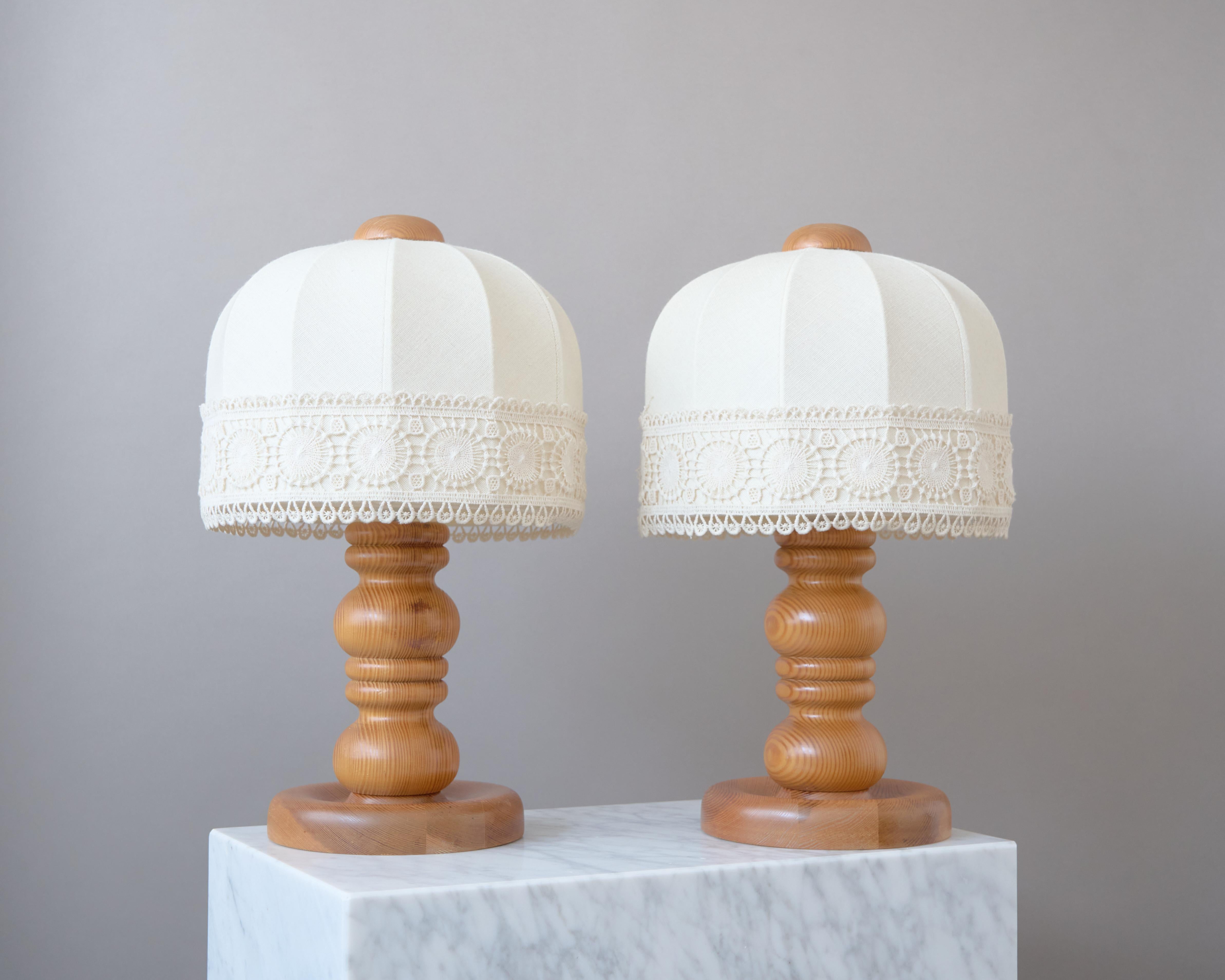 Pair of beautiful pine wood table lamps, with original linen shades and lace trim.

Made by Markslöjd AB in Sweden, 1970s.

Great original condition. 
Sold with the original lampshades.

Light source: E26/E27 screw bulb.
Number of Sockets (per