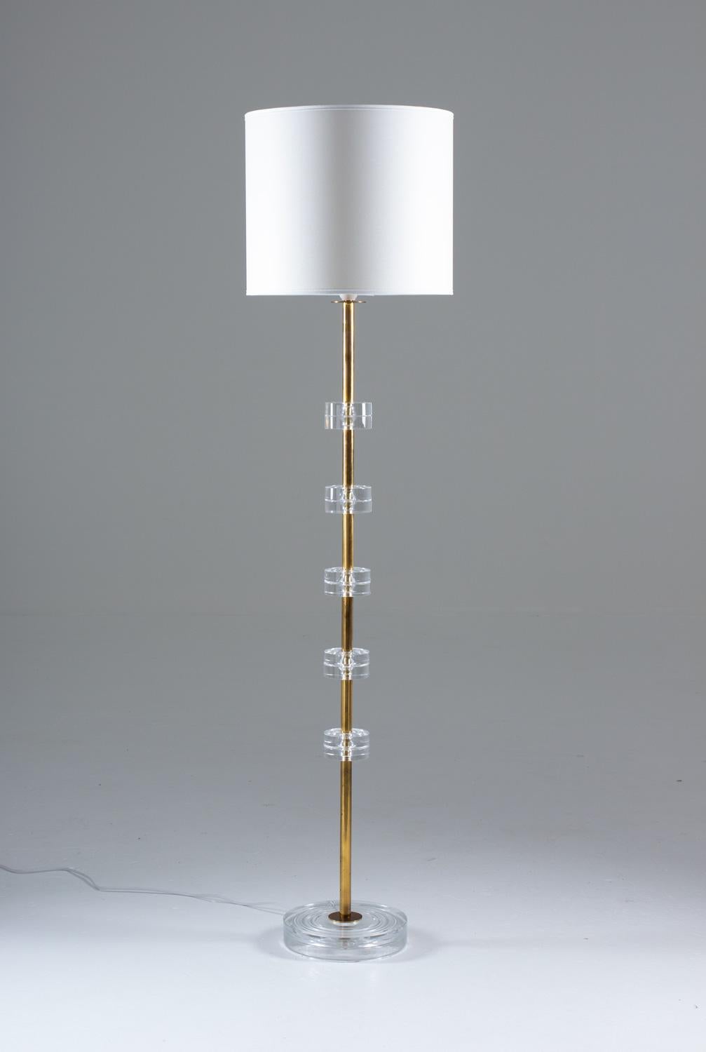 A pair of exclusive floor lamps by Carl Fagerlund for Orrefors. This model is among the best that Carl Fagerlund designed and they rarely appear as floor lamps. They feature crystal glass discs, separated by brass tubes and a bottom plate of crystal