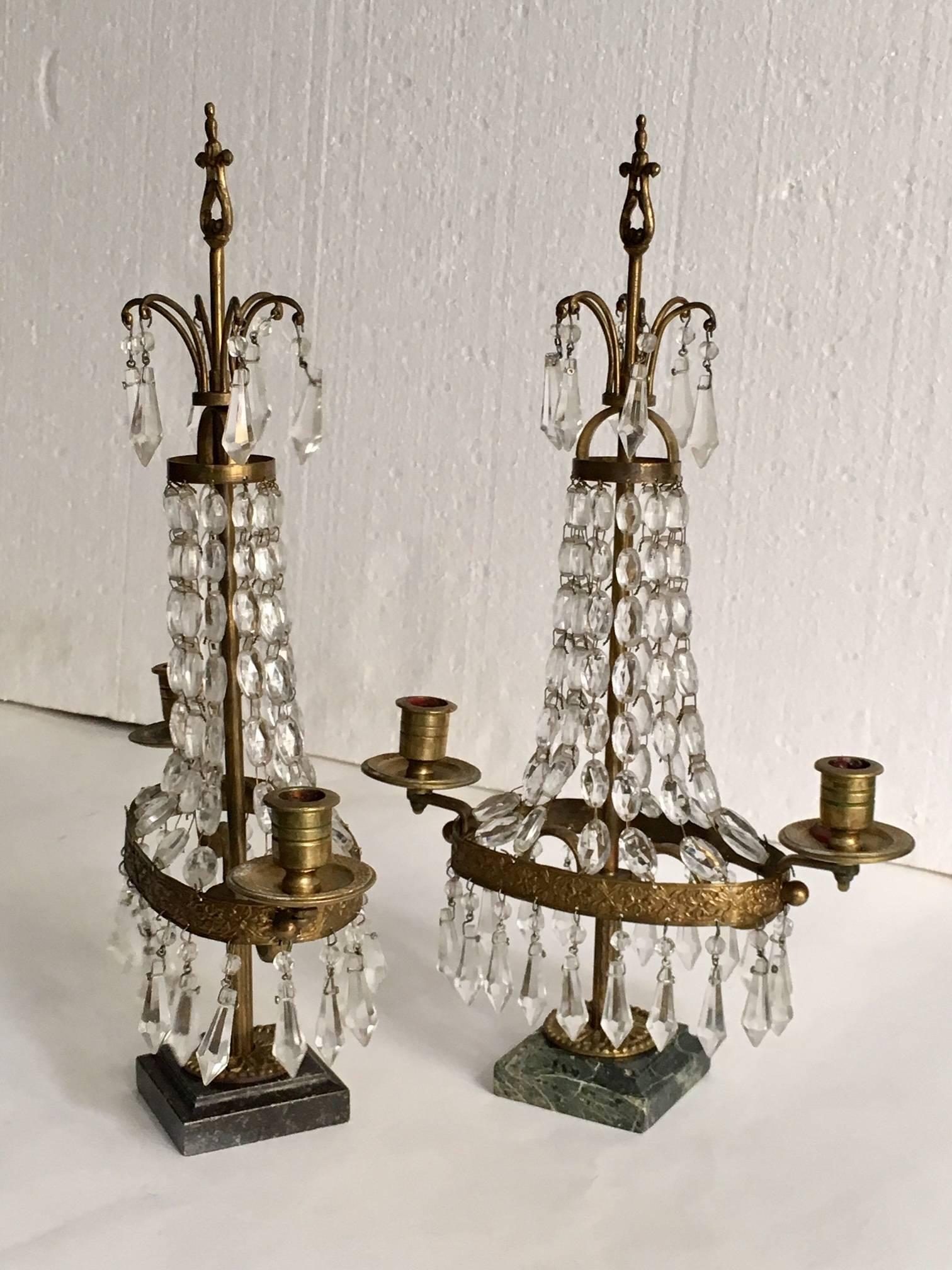 Pair of Swedish brass an crystal candelabra girandols, Louis XVI style on marble bases with cut crystal, each girandoles has two arms, each of which holds a single candle.