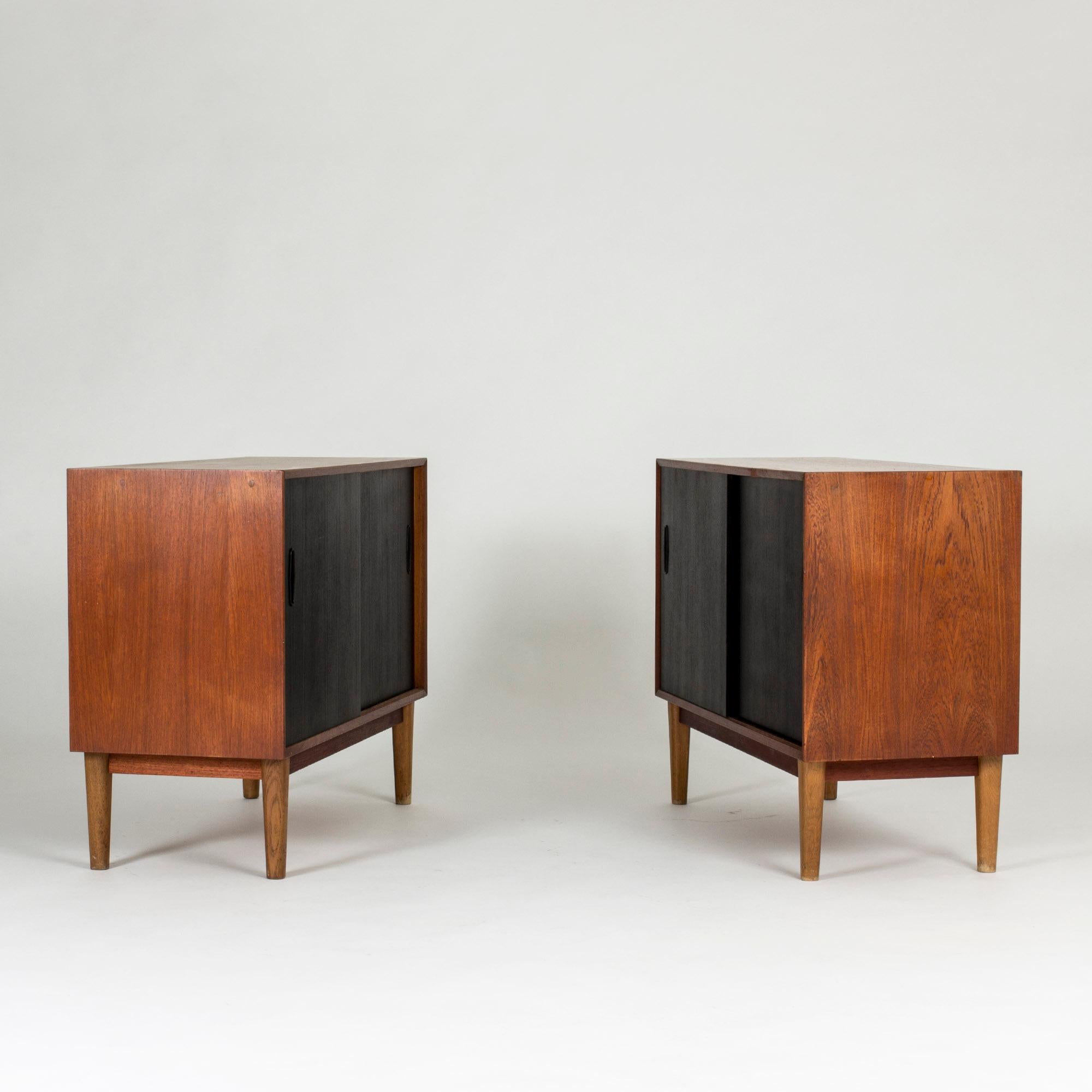 Pair of cool Swedish 1950s sideboards, made from teak with black lacquered front doors.