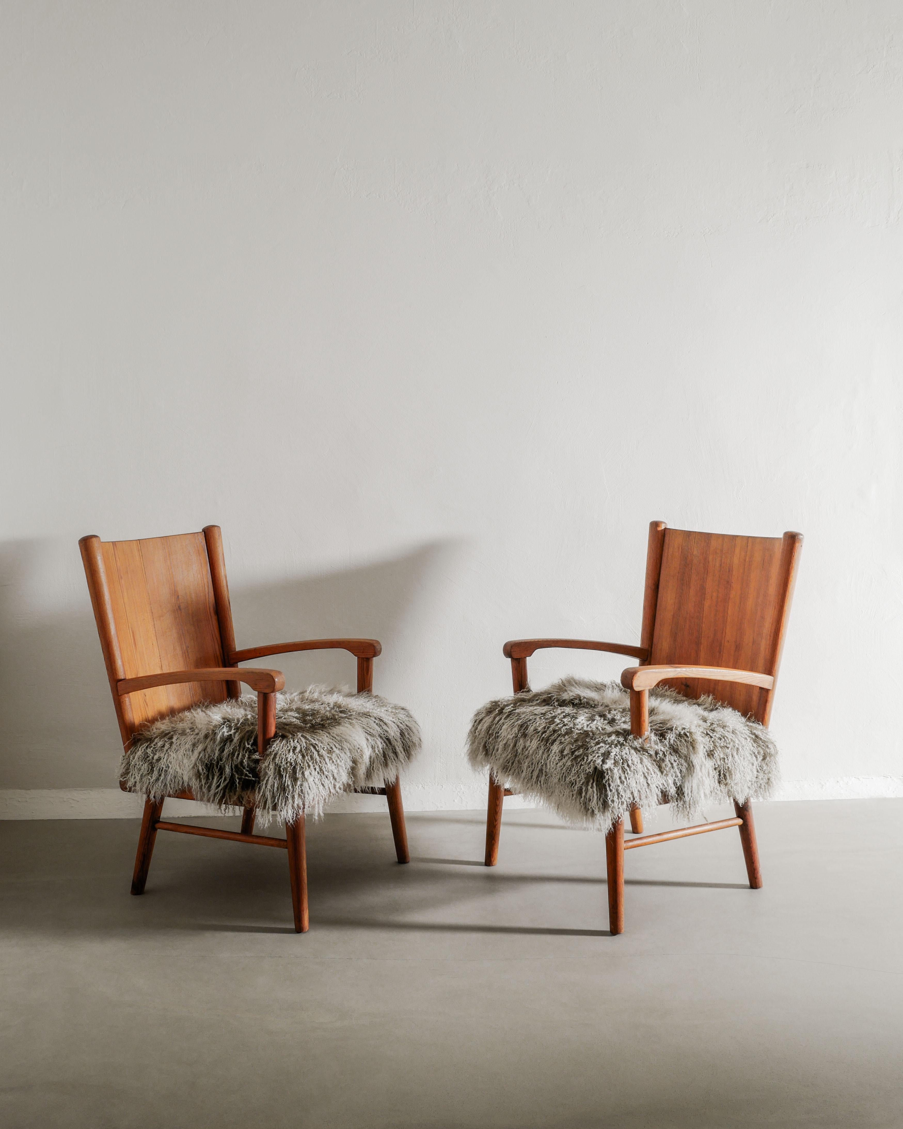 Una pareja muy rara y muy probablemente única de sillones suecos de madera de principios de la Edad Moderna de mediados de siglo, en pino, atribuidos a Axel Einar Hjorth y fabricados en Suecia, en la década de 1940. En magnífico estado vintage y