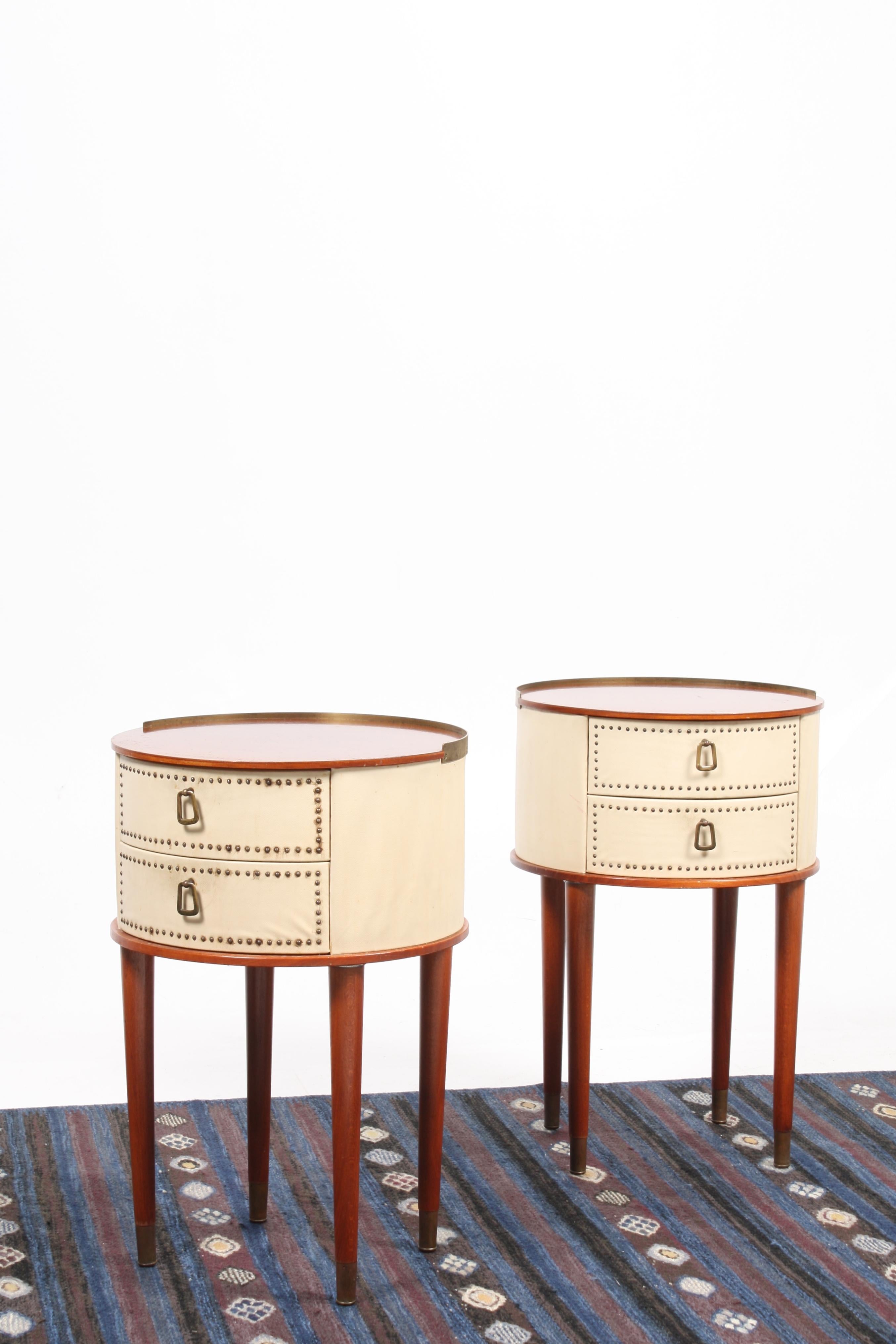 Pair of rare nightstands in mahogany and vinyl with hardware in patinated brass. Designed by Halvdan Peterson for Tibro Mobelfabrik circa 1940. Great original condition.