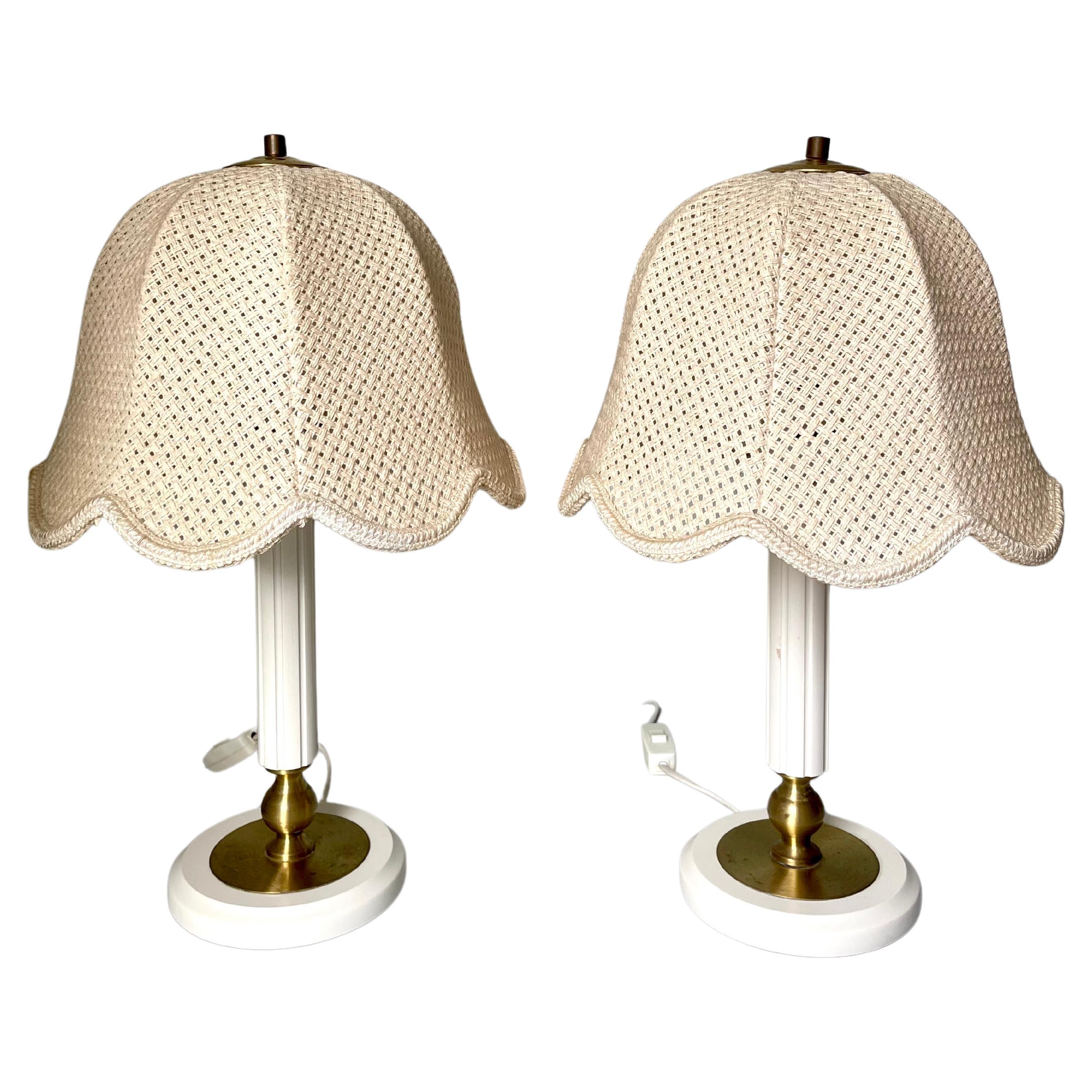 Pair of white, beige, cream Scandinavian Modern wooden table lamps manufactured by Markslöjd in the 1980s. Original braided tulip shaped cream colored textile shades with brass top. Slender lined cream white lacquered wooden neck and base with brass