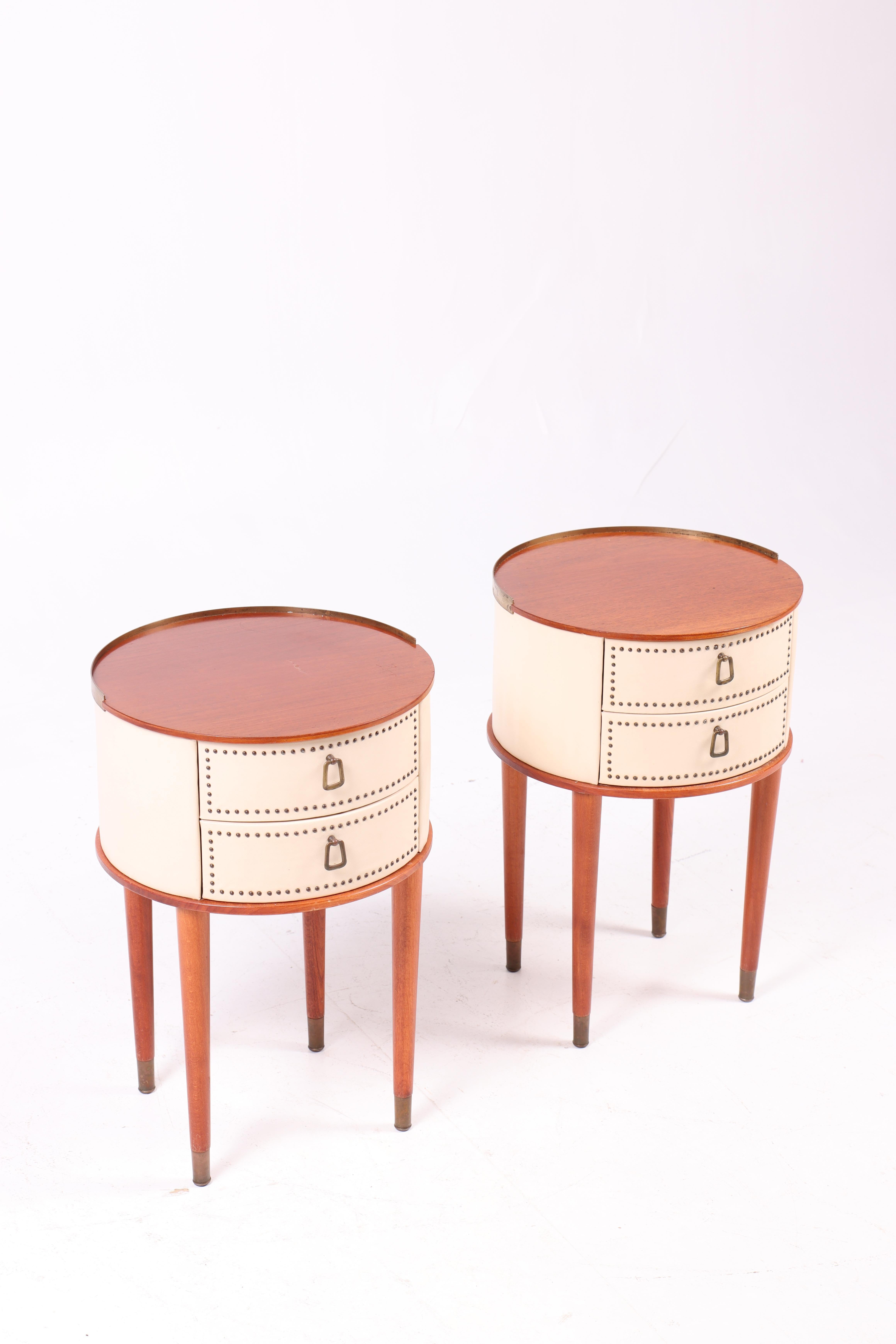 Pair of rare nightstands in mahogany and vinyl with hardware in patinated brass. Designed by Halvdan Peterson for Tibro Mobelfabrik circa 1940. Great original condition.