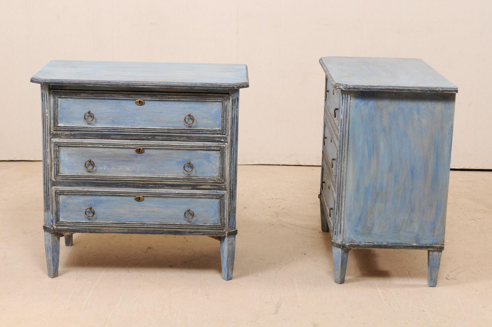 A pair of Swedish midcentury painted wood three-drawer chests. This pair of vintage chests from Sweden each feature three dovetailed drawers, trimmed in simple molding to emphasize their rectangular shapes, and are flanked by fluted side posts down