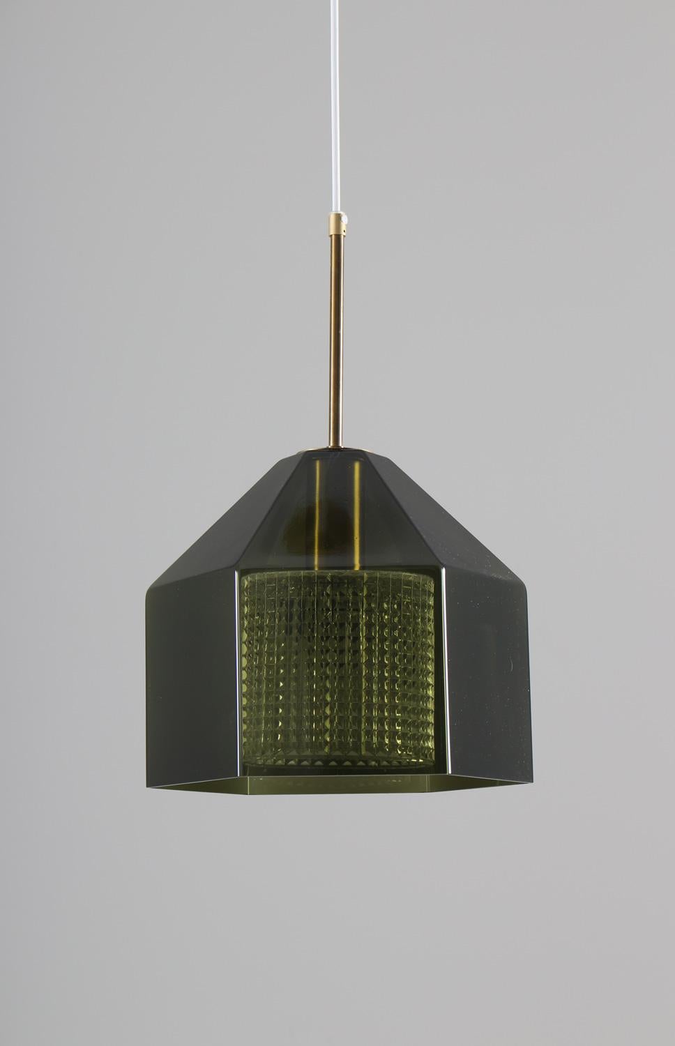 Beautiful pendants in crystal glass and brass. The lamps feature a green hexagonal glass shade and a clear glass innershade. 

Condition: Very good, age related patina on the brass. One minimal dent on glass on one of the lamps.
    