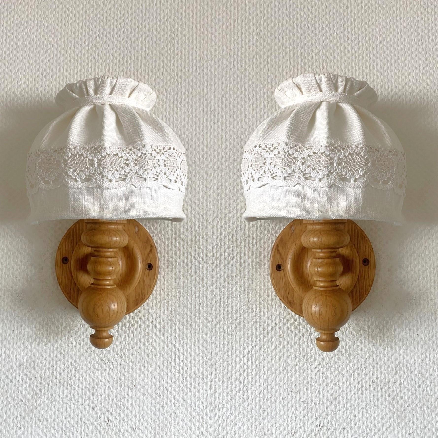 Pareja de apliques de madera de pino tallados a mano, diseñados y fabricados en Suecia en la década de 1950. Líneas limpias y  diseño del periodo moderno escandinavo, con preciosas pantallas de lino hechas a mano. Ambos apliques en muy buen estado