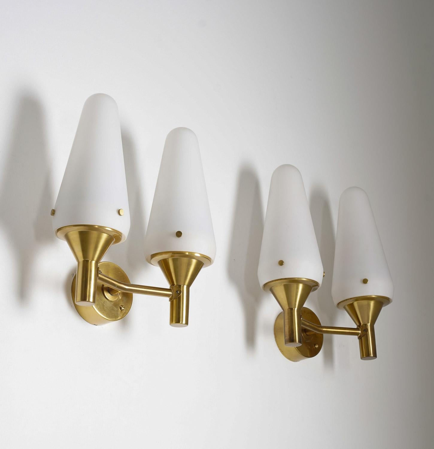 Pair of Hans-Agne Jakobsson wall lights manufactured by Hans-agne Jakobsson circa 1950.
Each lamp features two light sources, hidden by a large frosted opaline glass shade. The shades are kept in place by brass screws. 

Condition: Very good