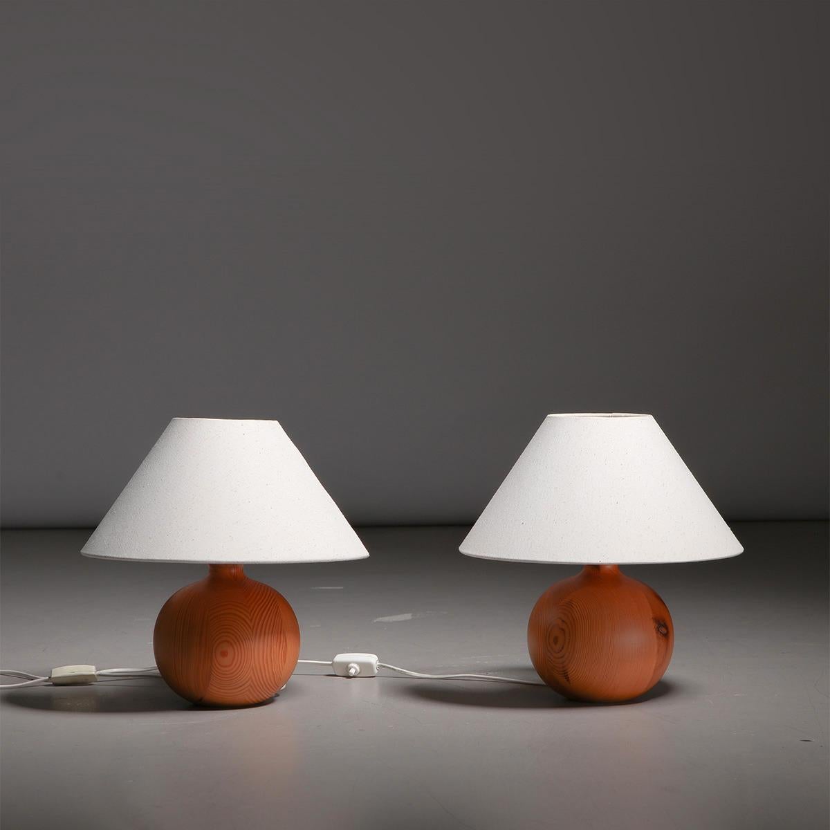 Pair of Swedish minimalist table lamps in pine, manufactured in Sweden, 1960s.

Crafted from pine, this pair of Swedish minimalist table lamps was made in the 1960s by a talented Swedish cabinetmaker. Each lamp features a gorgeous round-shaped pine