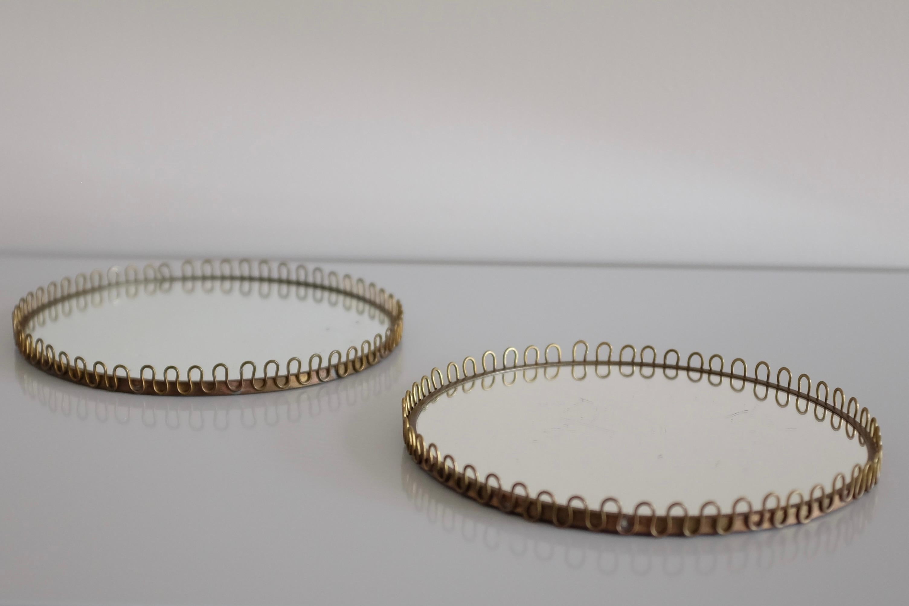 Pair of Swedish Mid-Century Mirror tray in brass and glass with an oval filigree design. Made by GAF Svenskt Handarbete Sweden during the 1950s. In good vintage condition with a nice shine to the brass and age appropriate wear to the glass with some