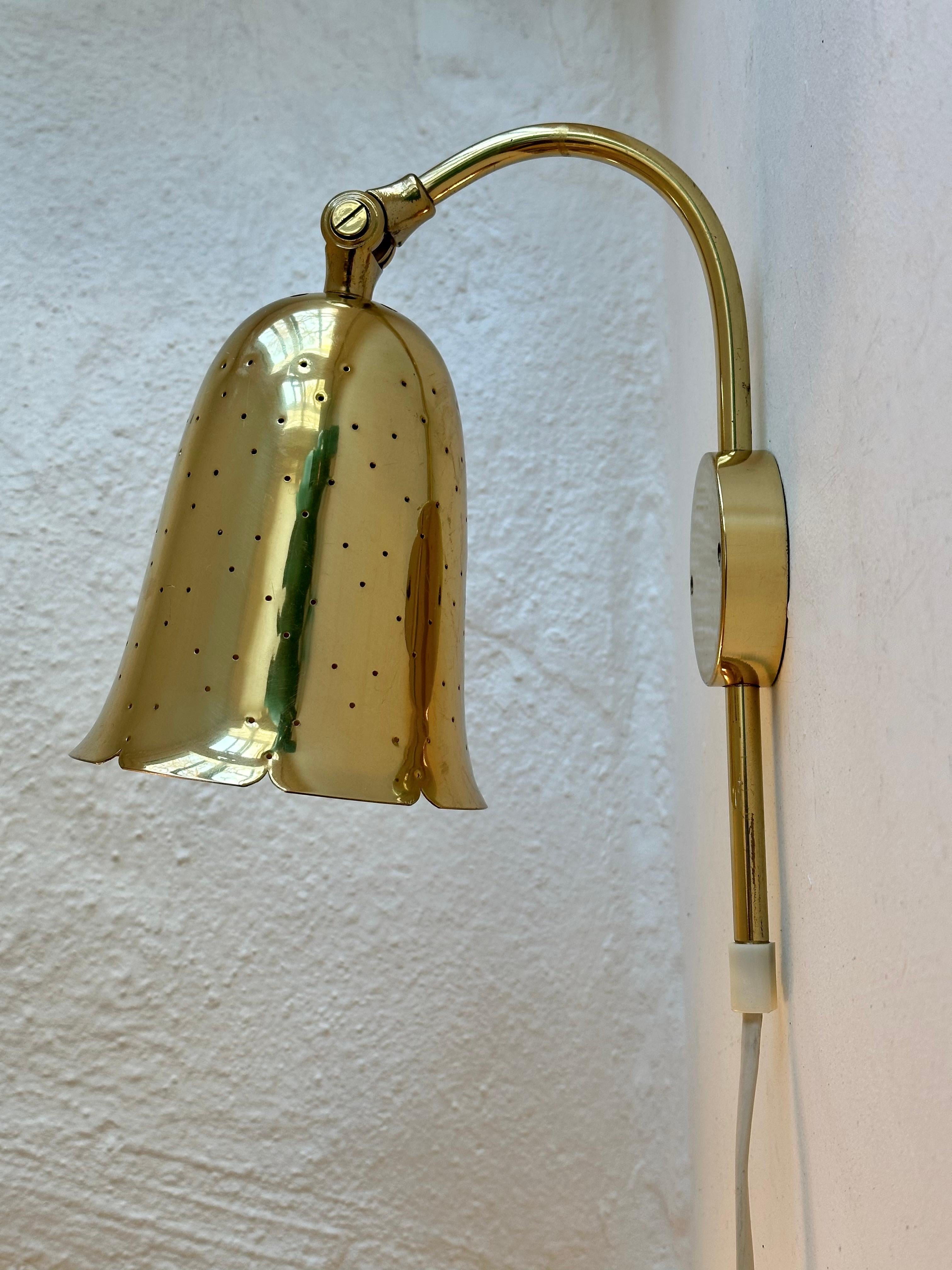 Rare wall lamps in brass produced by Boréns in Borås, Sweden. Perforated brass shades creating a beautiful pattern when lit. Adjustable height and angle. Model No. 6972.