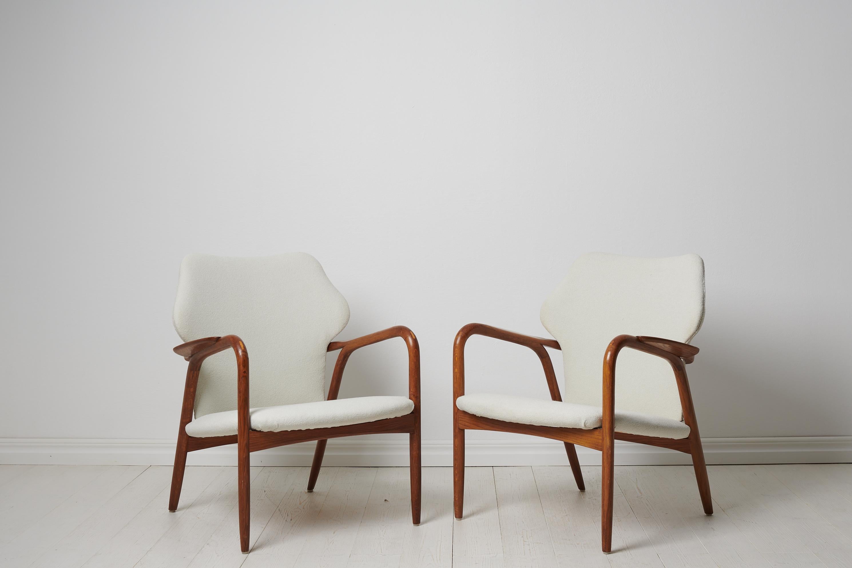 Swedish modern white armchairs made in Sweden around the mid 20th century, 1950 to 1960s. The pair is renovated with newly upholstered seats. The frame is made in stained oak.