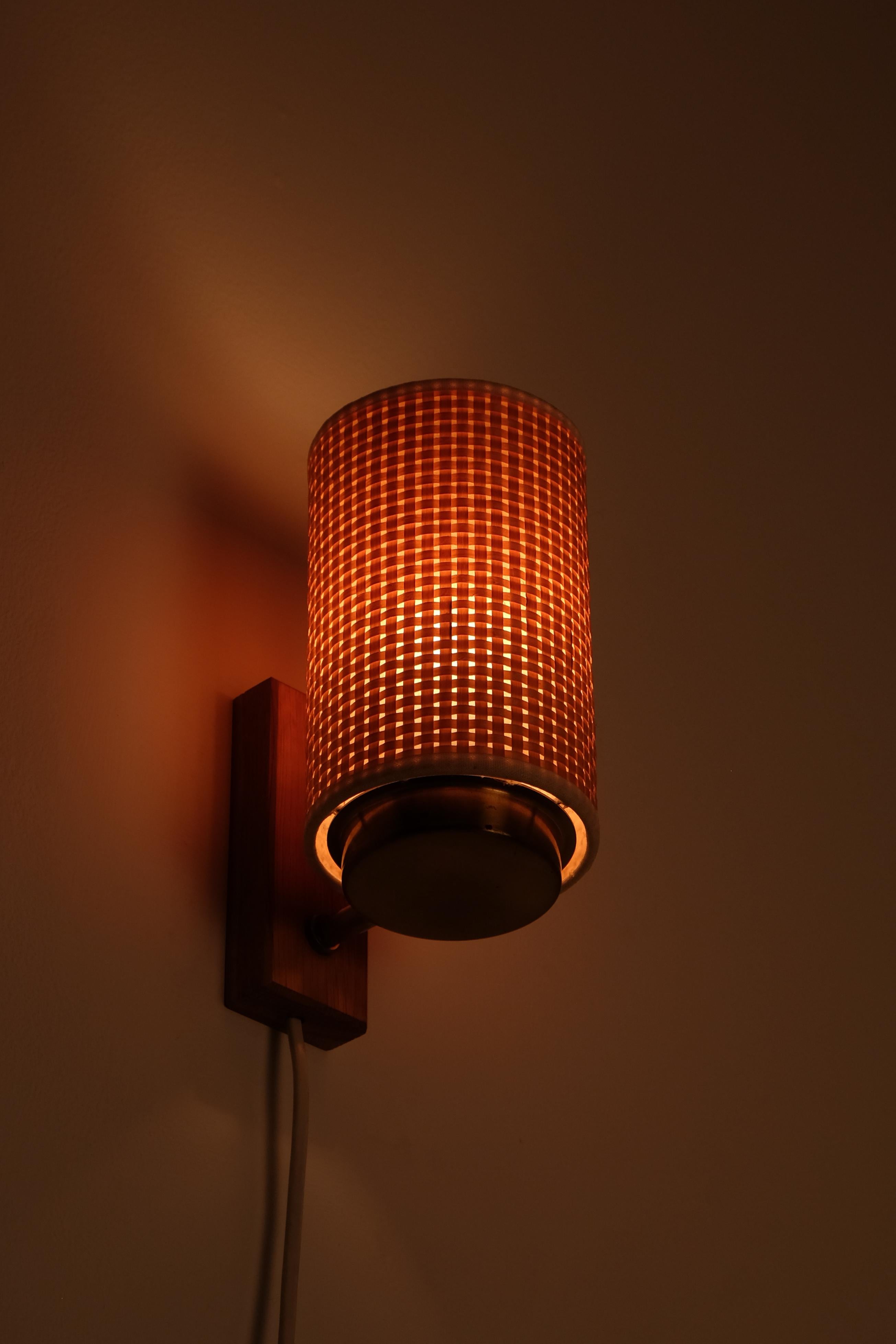 Pair of wall lamps with brass, teak and cane. Produced in Sweden, probably by Ateljé Lyktan, 1950s. 
