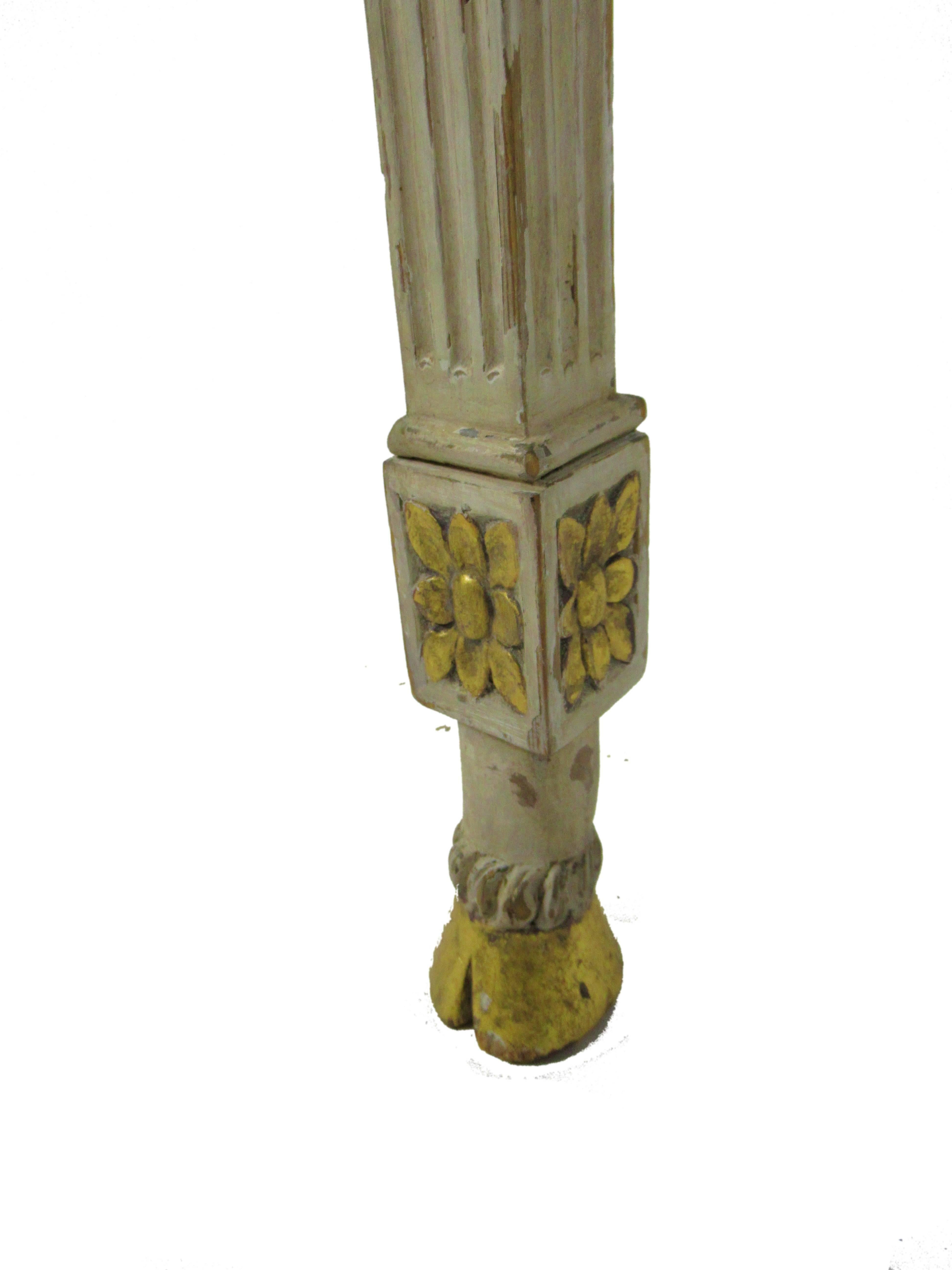 The demilune top above a fluted freeze with a central carved ram’s head and carved rosettes, on a single fluted leg terminating with a hoof foot- wall attached consoles, 18th century.