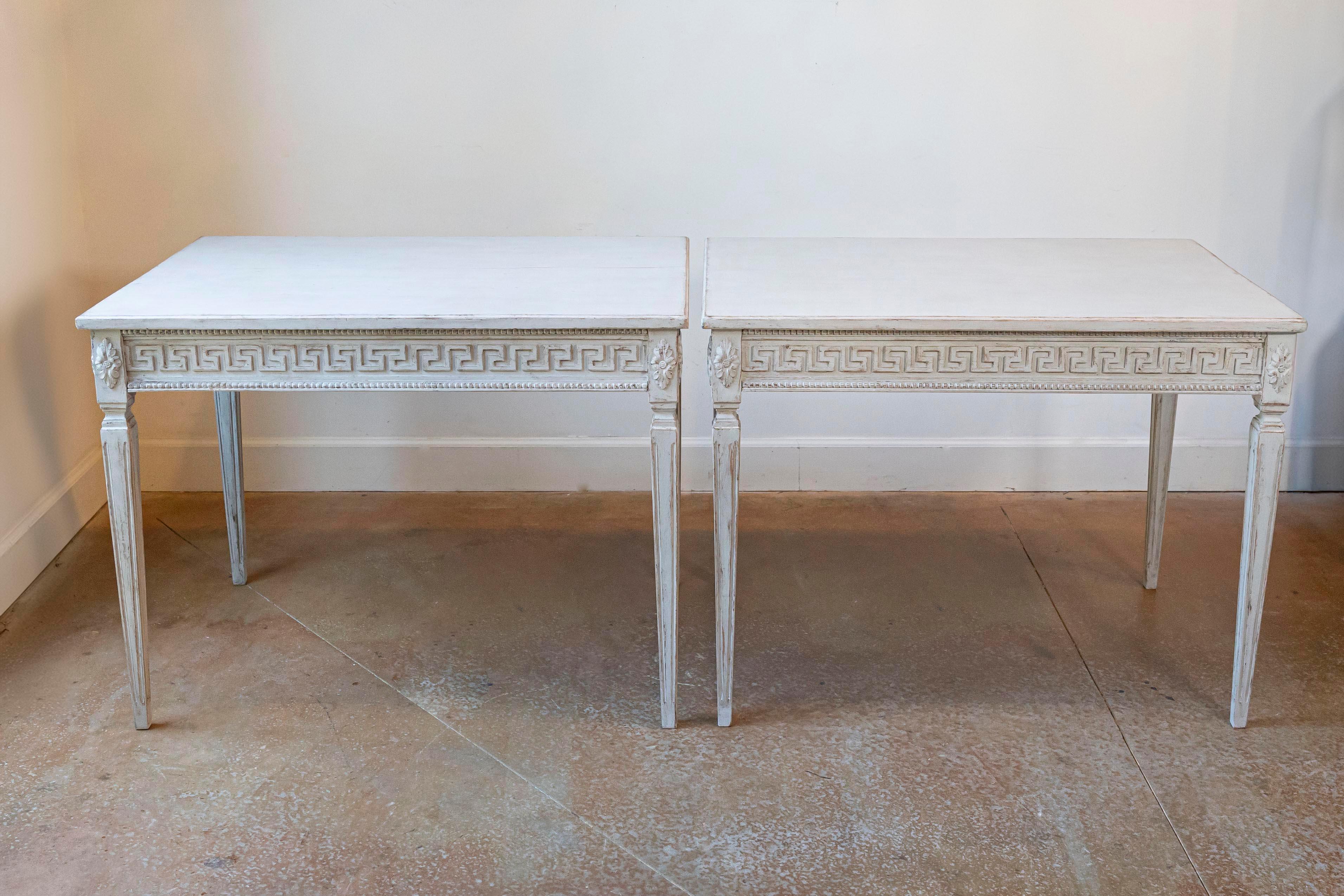 Ein Paar schwedische Beistelltische aus bemaltem Holz im neoklassizistischen Stil aus dem späten 19. Jahrhundert mit geschnitzten griechischen Schlüsselfriesen, verjüngten Beinen und Rosettenmotiven. Dieses Beistelltischpaar wurde im letzten Viertel