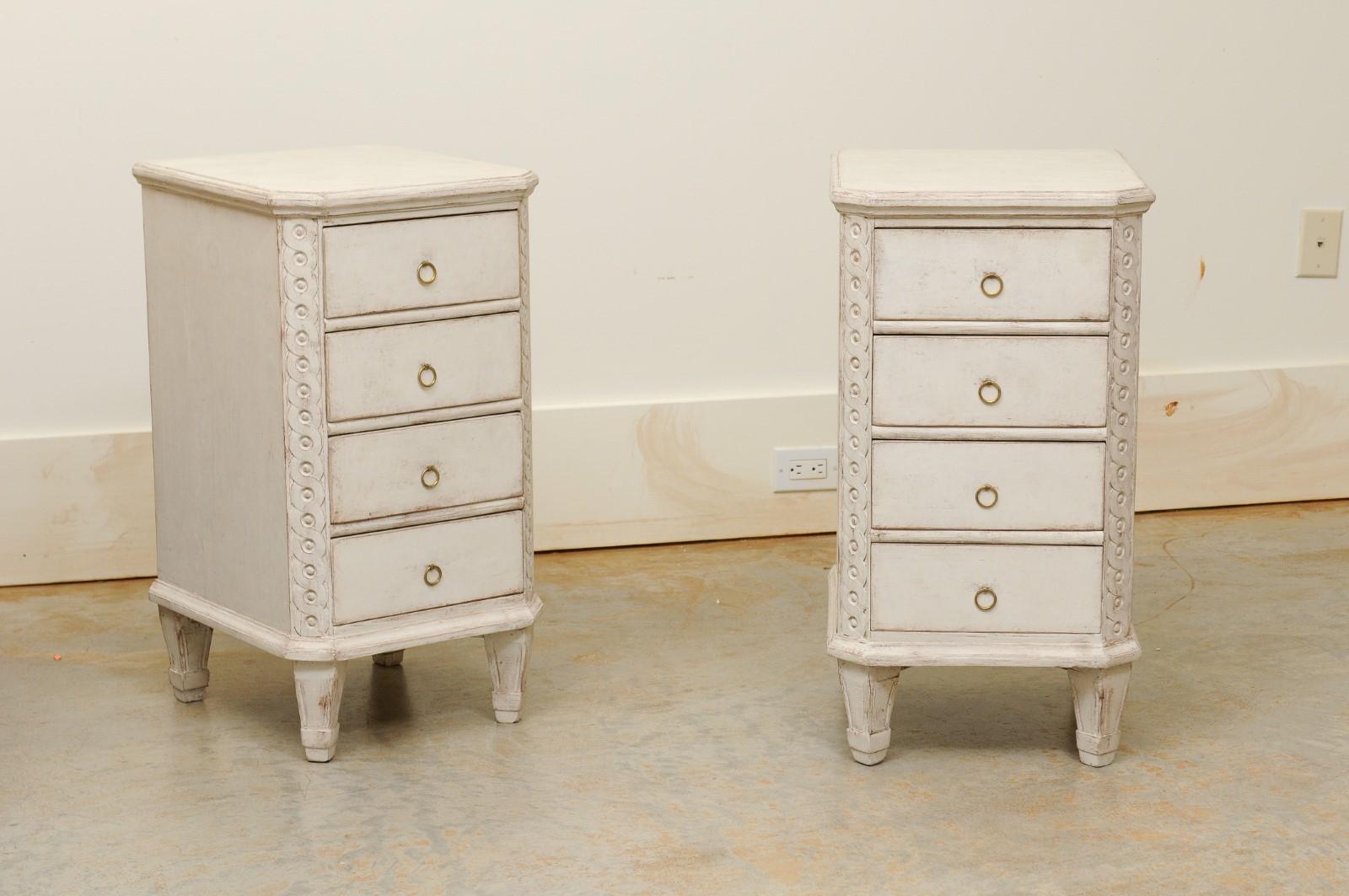 A pair of Swedish neoclassical style painted nightstand tables from the 19th century, with guilloche motifs, drawers and canted sides. Created in Sweden during the 19th century, each of this pair of bedside tables features a rectangular top with