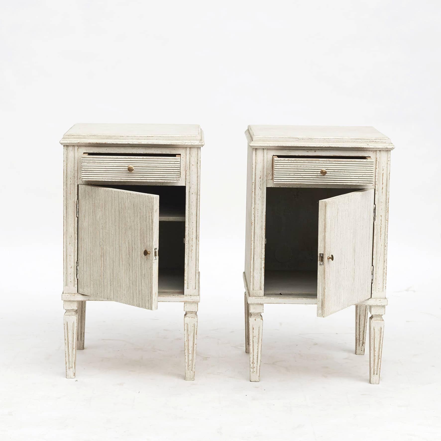Pair of Gustavian style nightstands or bedside cabinets.
Fluted cupboard doors and drawers with brass knobs. Fluted tapered legs.

Sweden, mid-19th century.