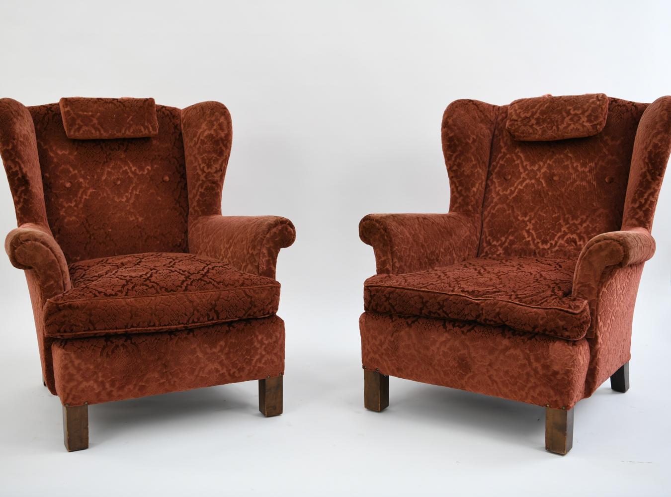These 1940s Swedish wingback chairs by Nordiska Kompaniet scream comfort and elegance. Featuring luxuriously patterned red upholstery with matching head pillows. These fine chairs were made at the time where designers as Carl Malmsten, Axel Einar