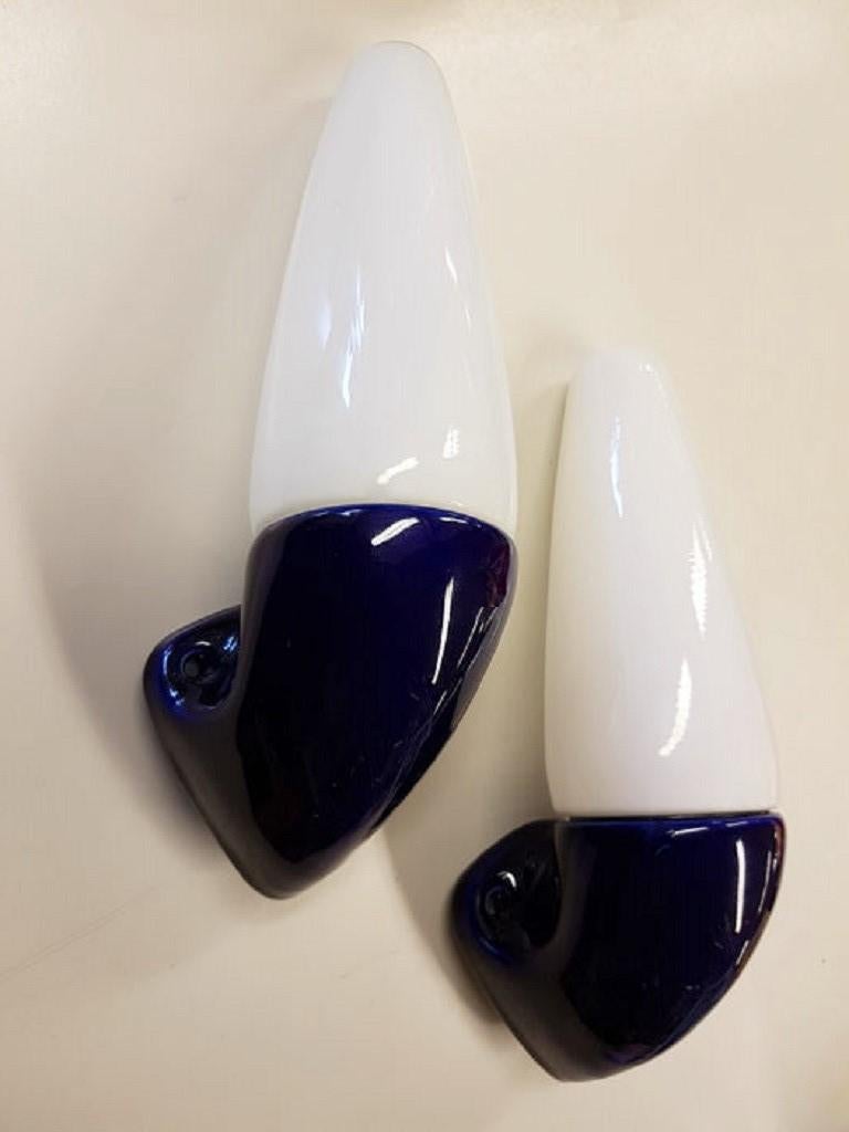 A pair of vintage Swedish wall lamps with opaline glass shades and cobalt blue glazed ceramic, designed by Sigvard Bernadotte for Ifö, 1960s.
 