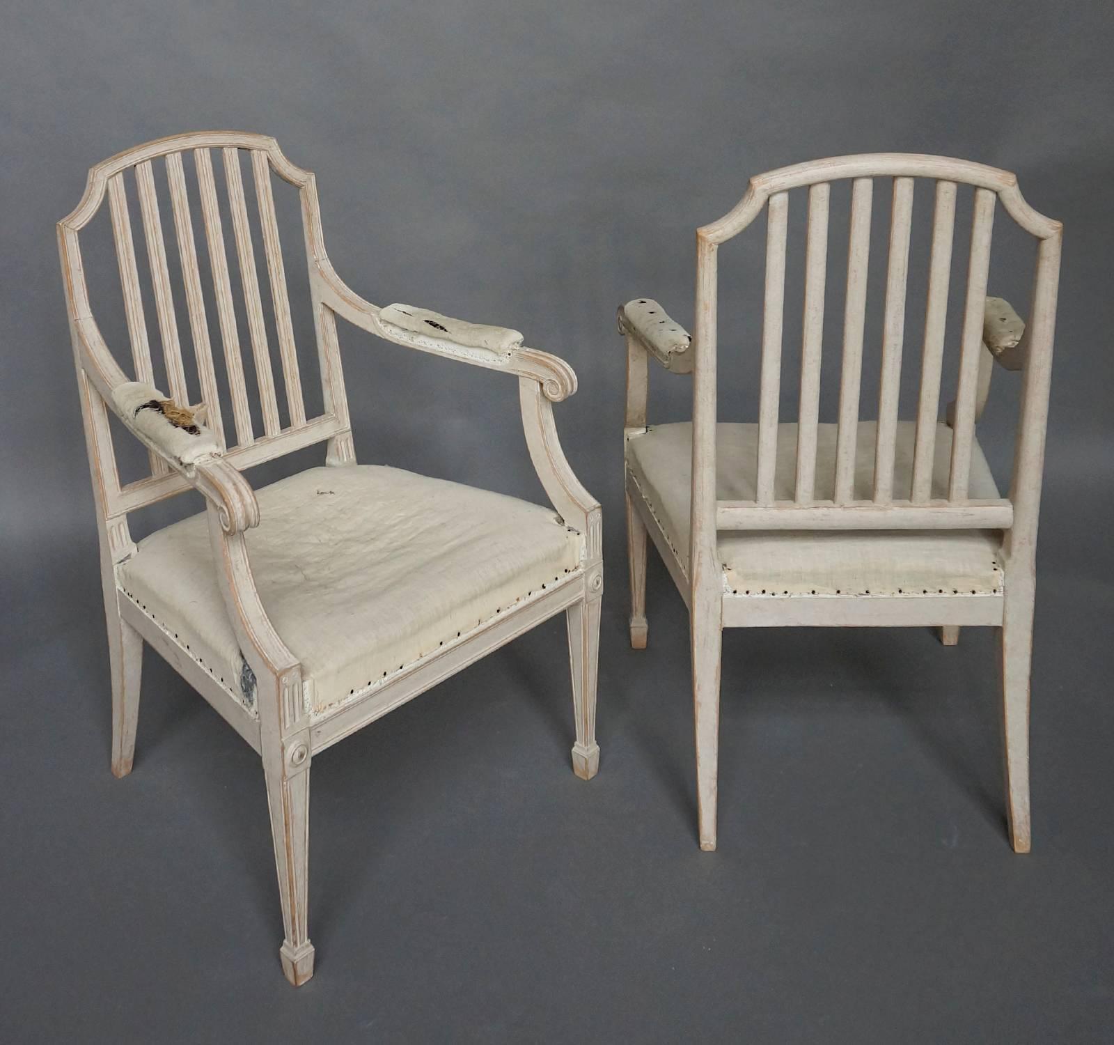 Pair of refined neoclassical style open armchairs, Sweden circa 1900. The arched baluster back extends smoothly into the padded arms which end in elegant scrolls. The front legs are square and tapering, and terminate in spade feet. Roomy,
