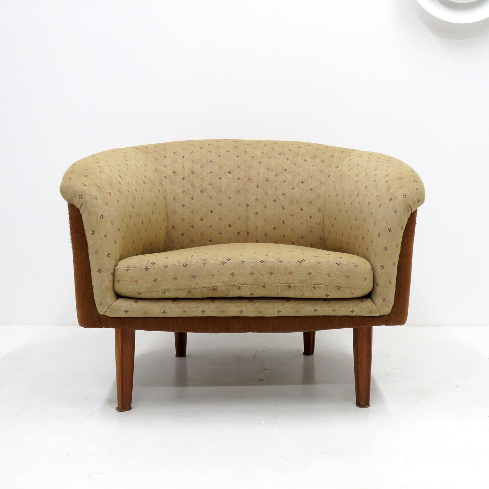 Merveilleuse paire de chaises longues suédoises surdimensionnées, 1960, avec un revêtement floral beige d'origine avec des accents colorés et des pieds cannelés en acajou, le tissu marron noisette sur les côtés des chaises montre une usure mineure.