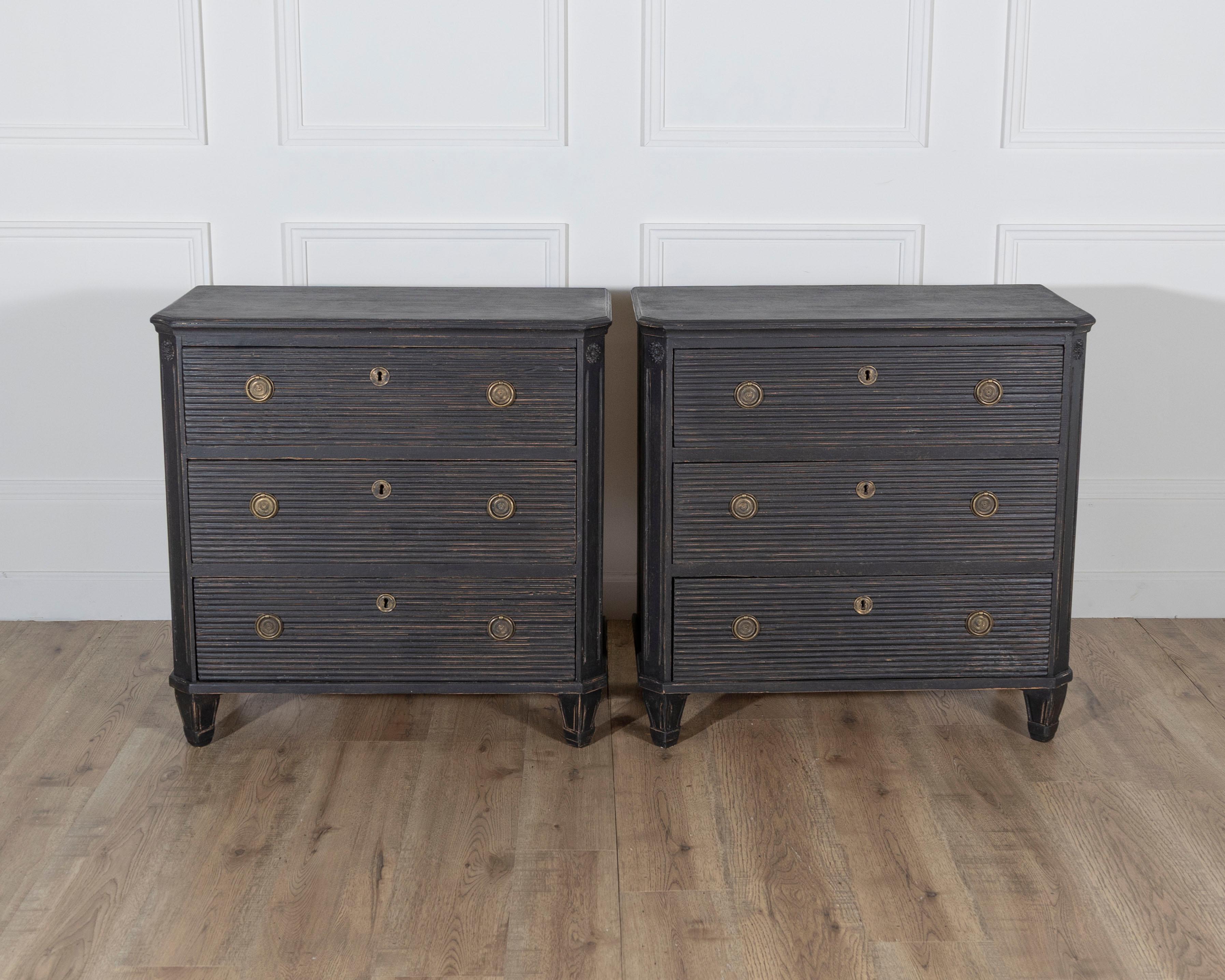 This striking pair of Swedish chests of drawers, dating to circa 1880, showcases the timeless elegance and craftsmanship of late 19th-century Scandinavian design. Each chest features three spacious drawers with beautifully patinated, reeded fronts