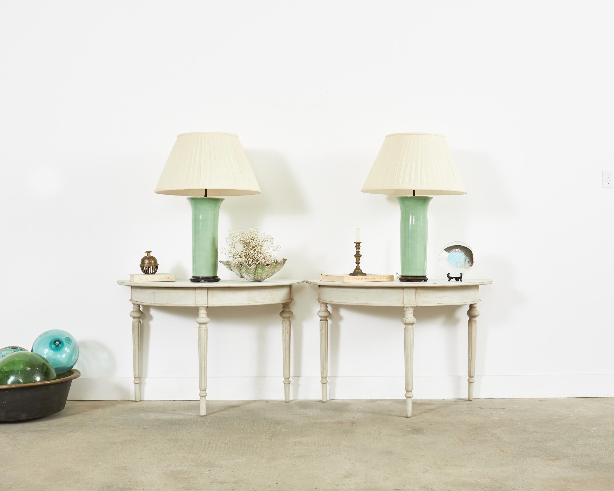 Exquisite pair of Swedish demi-lune console tables made in the Gustavian taste. Crafted from pine with a later painted finish. These tables were ends of a large banquet table and fit together to form a 45.5 inch round dining table or center table.