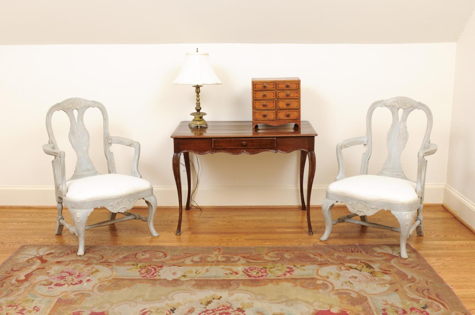 Paire de fauteuils suédois en bois peint de style rococo, datant de la fin du XIXe siècle, avec cannelures sculptées, pieds cabriole et tapisserie d'ameublement. Créée en Suède au cours de la dernière décennie du XIXe siècle, cette paire de