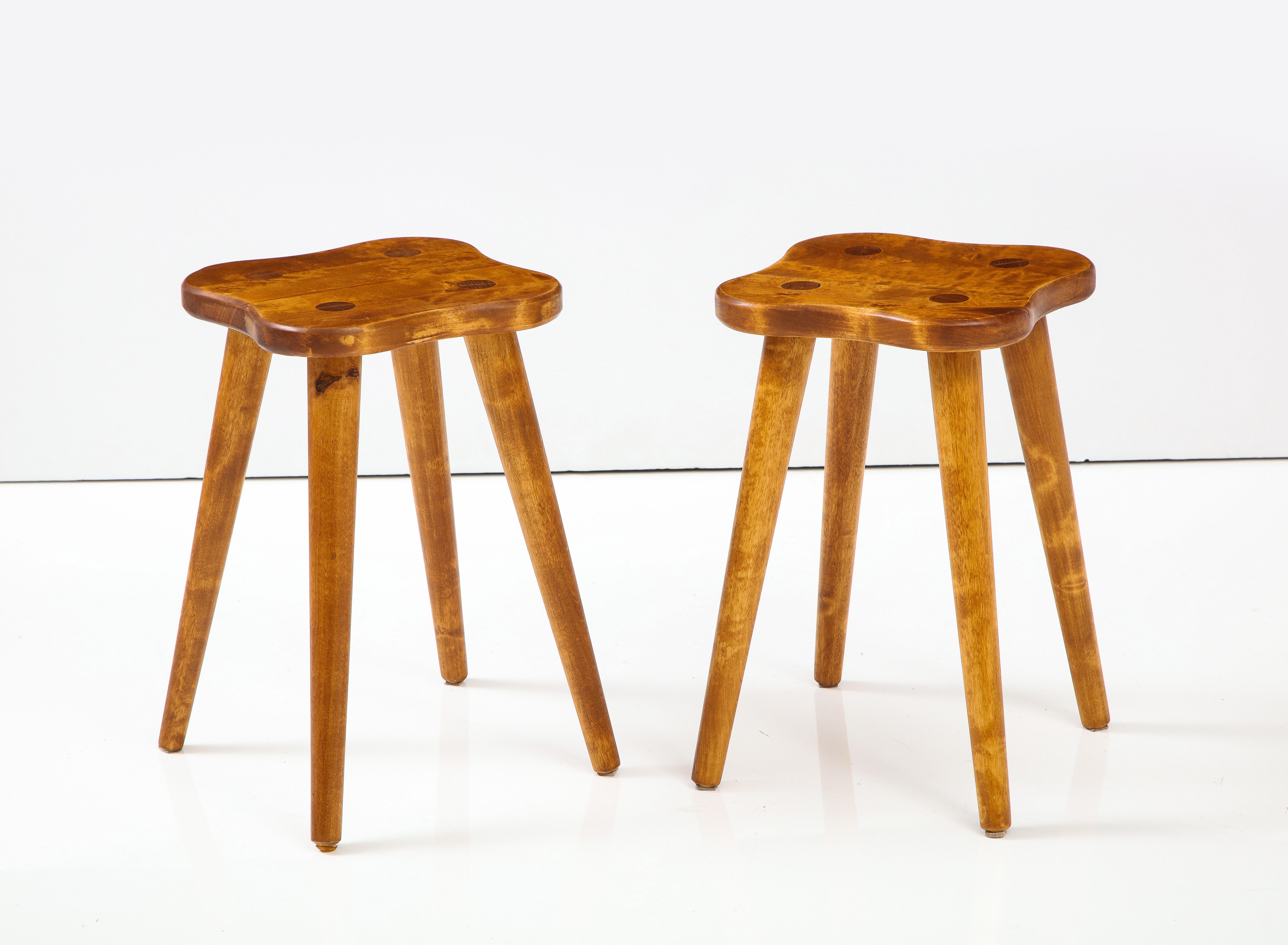 A pair of Swedish solid birch stools or side tables, circa 1960s, each with a incurved sided top raised on circular turned legs with seat dowels. Stain and wax finish. They would make nice little pull up stools or side tables.