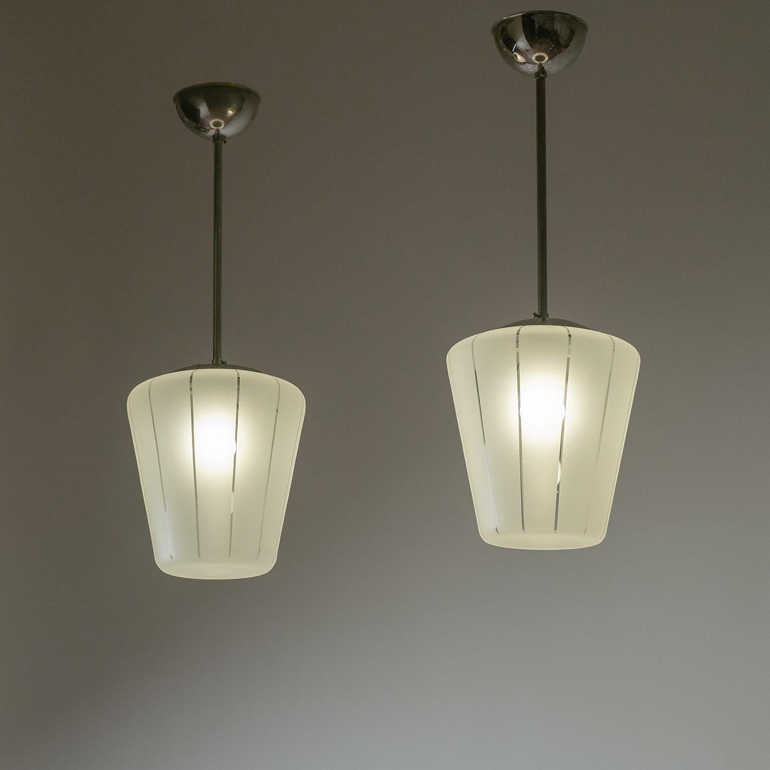 Raffinata coppia di pendenti svedesi in vetro e nichel degli anni 1940-1950. I diffusori conici in vetro sono smerigliati all'esterno e con gessature trasparenti. Buone condizioni originali con un po' di patina sul nichel. Le coperture in vetro di