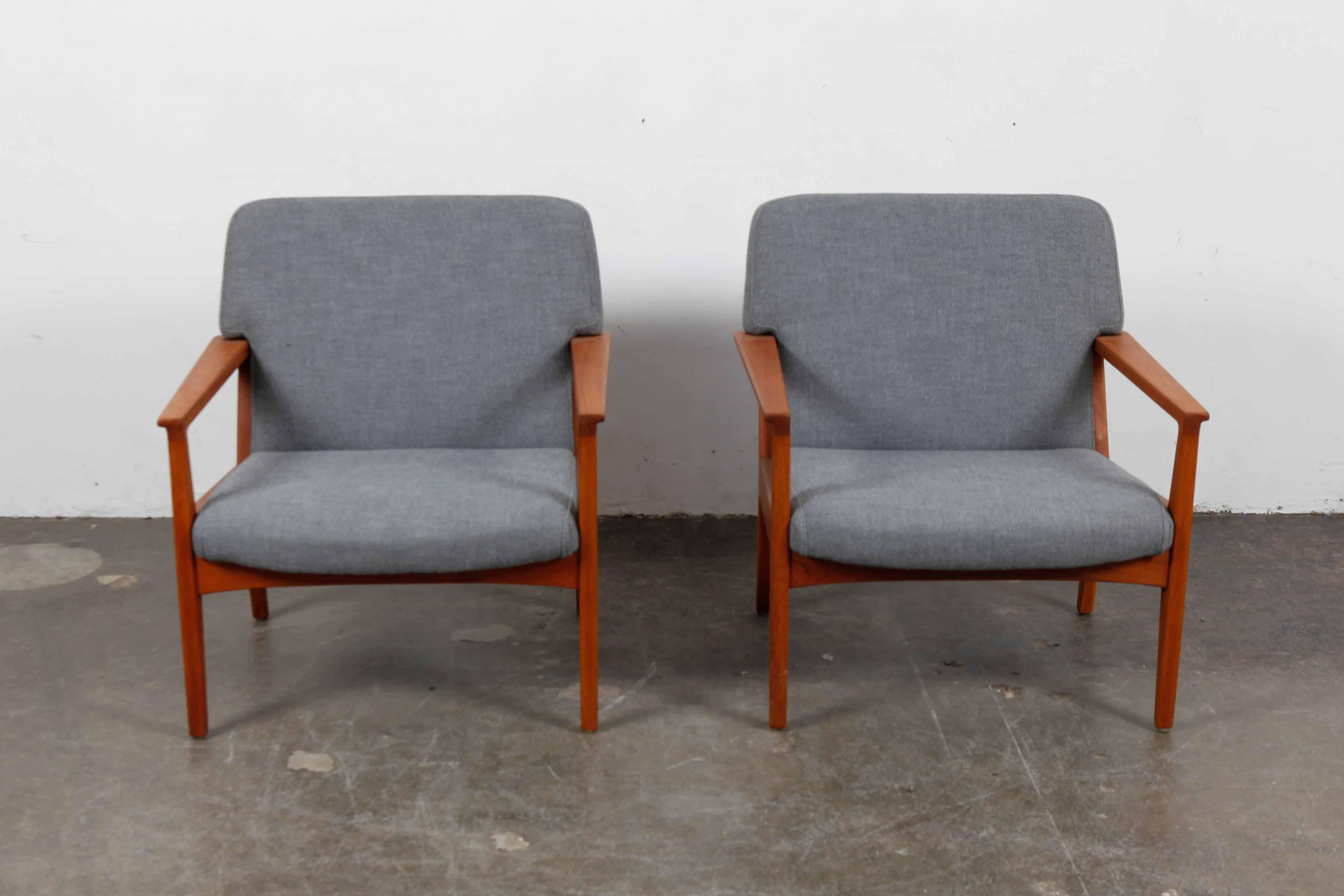 Pair of solid teak framed lounge chairs with fully upholstered seat and back, sleek angular lines, 1960s, Sweden. Newly upholstered in a gray heavy weight woven linen fabric and newly refinished in a matte teak oil finish.