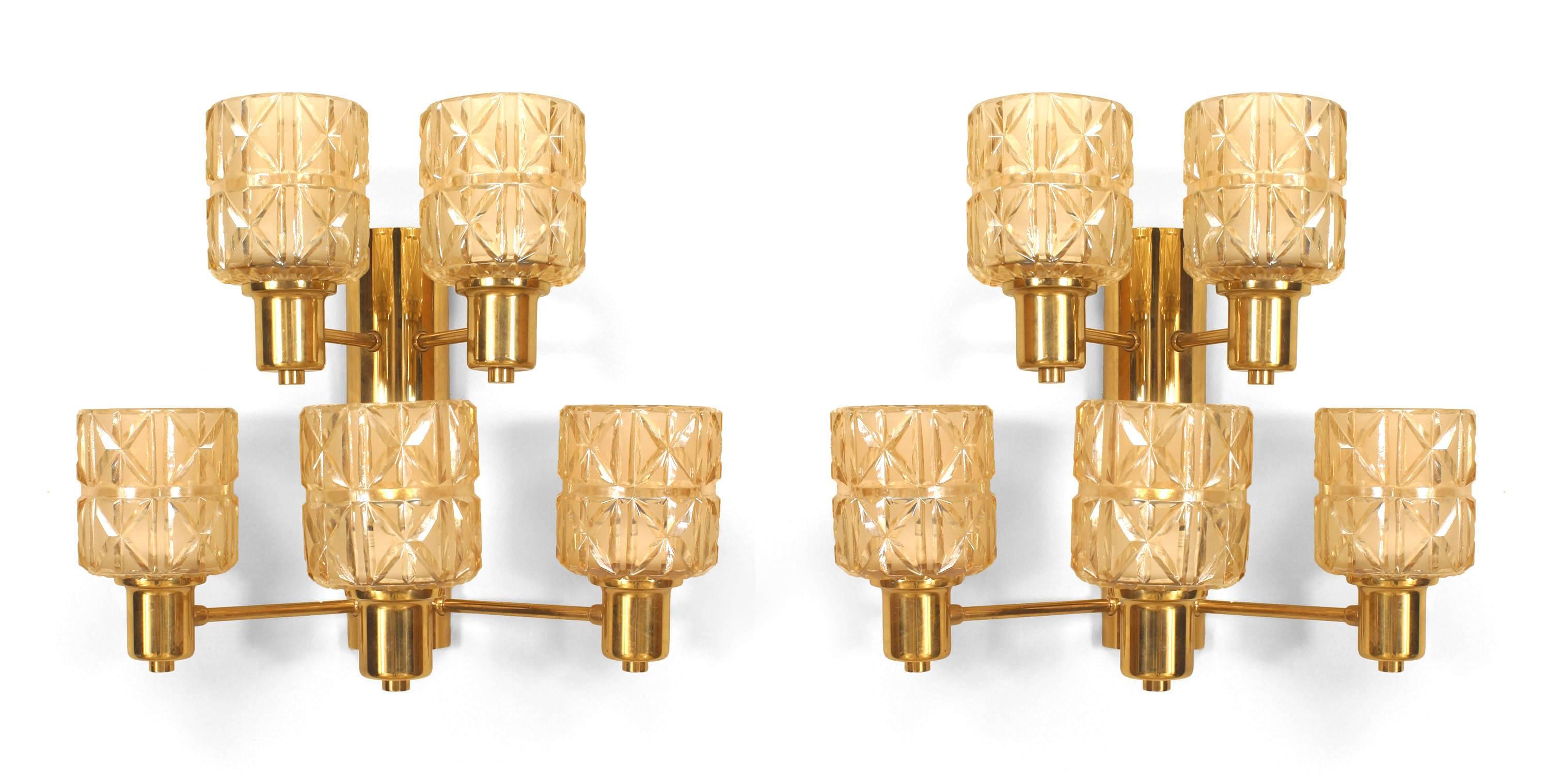 Pair of Swedish Mid-Century (1950s) wall sconces with a two-tier brass frame supporting two cut glass shades on the upper tier and three shades on the lower (attributed to HANS AGNE JAKOBSEN)

