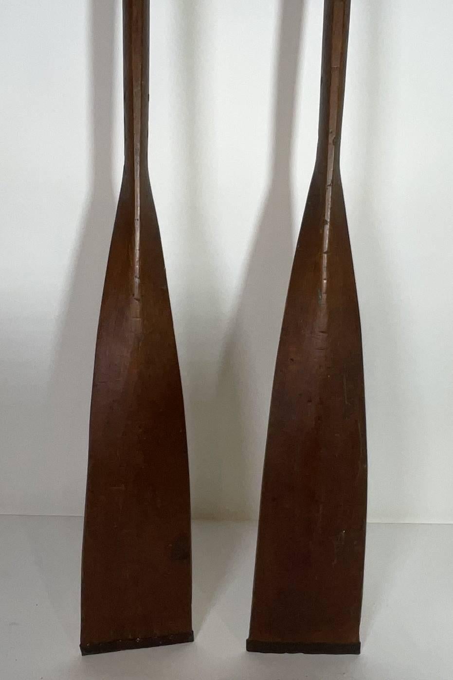 Choix d'une paire de balais d'aviron. Riche patine d'usage. Pointes en métal. Colliers en cuir. 98