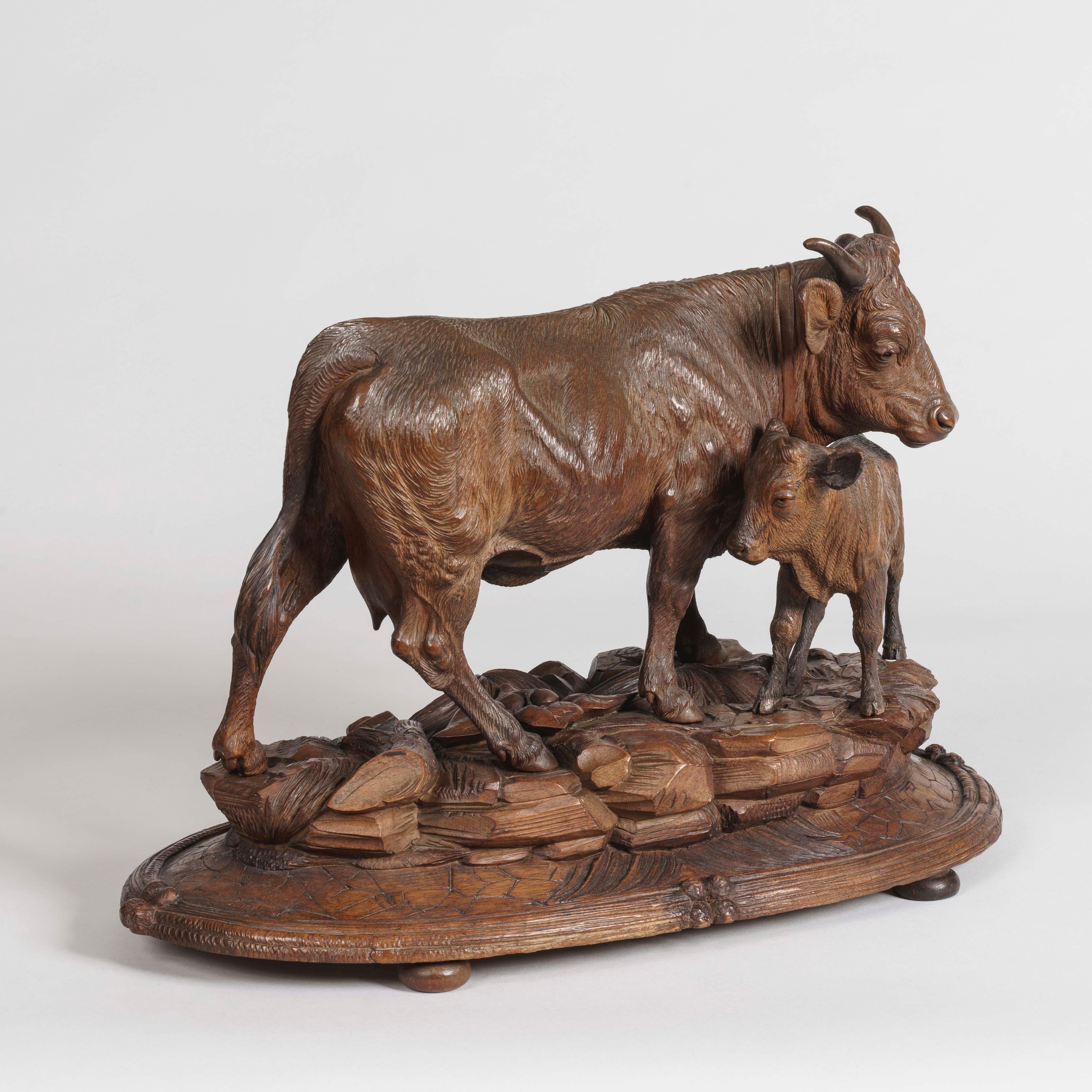 A pair of Black Forest cattle
attributed to Johann Huggler

Carved in lindenwood, the naturalistically carved Swiss cow, calf and bull stand on elliptical bases of grass and rocky outcrops, resting on bun feet.
Brienz Area, circa 1870

Johann